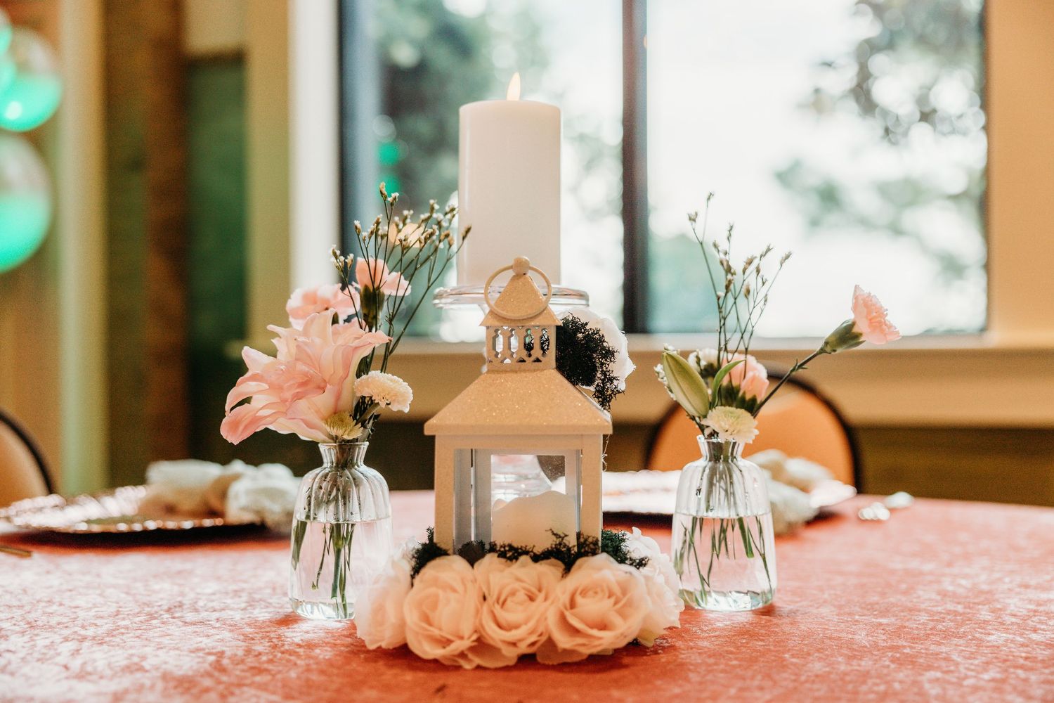Wedding reception table setup with delicate floral centerpieces and white table linens.