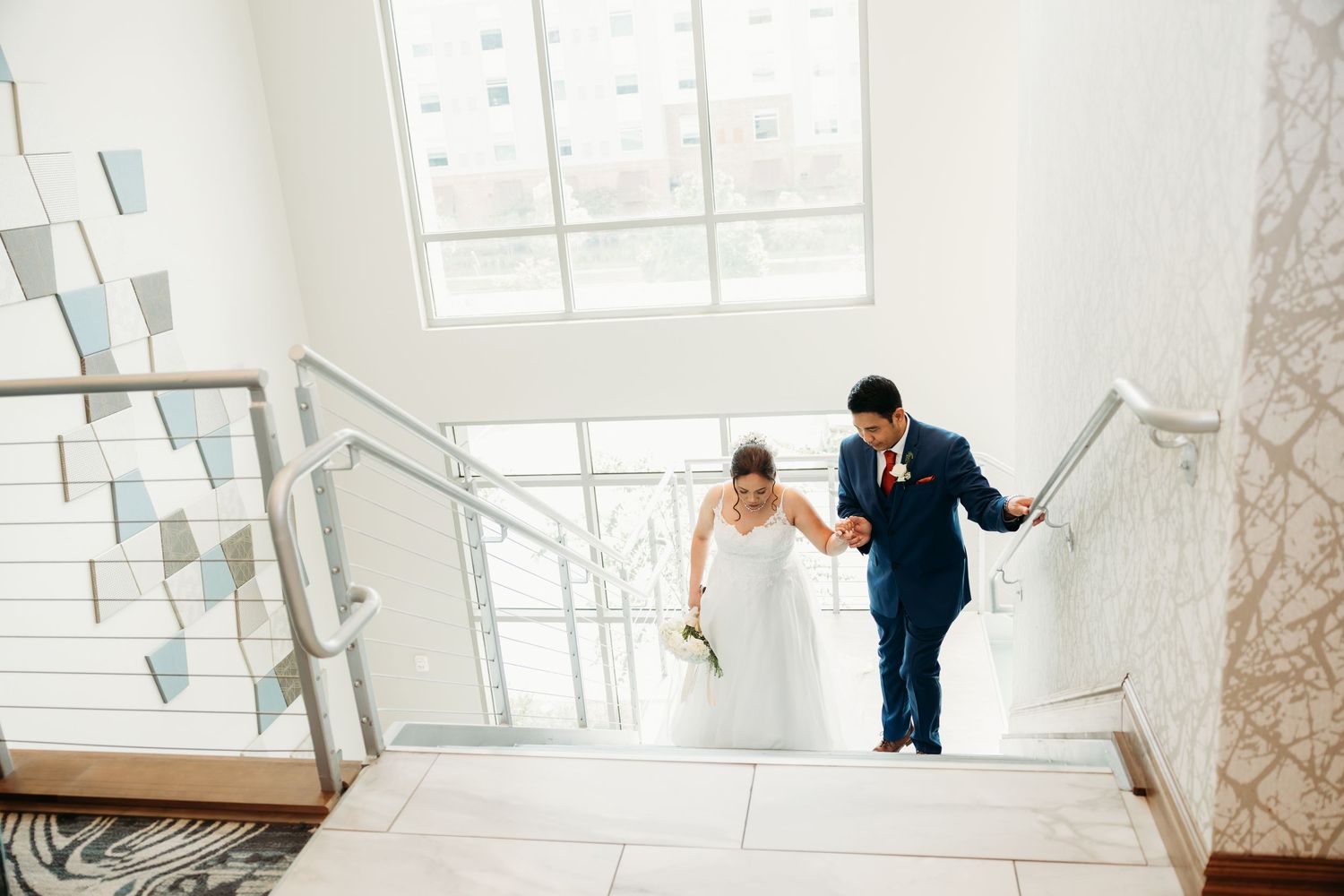 Wedding couple sharing an intimate moment in a bright white modern interior space.