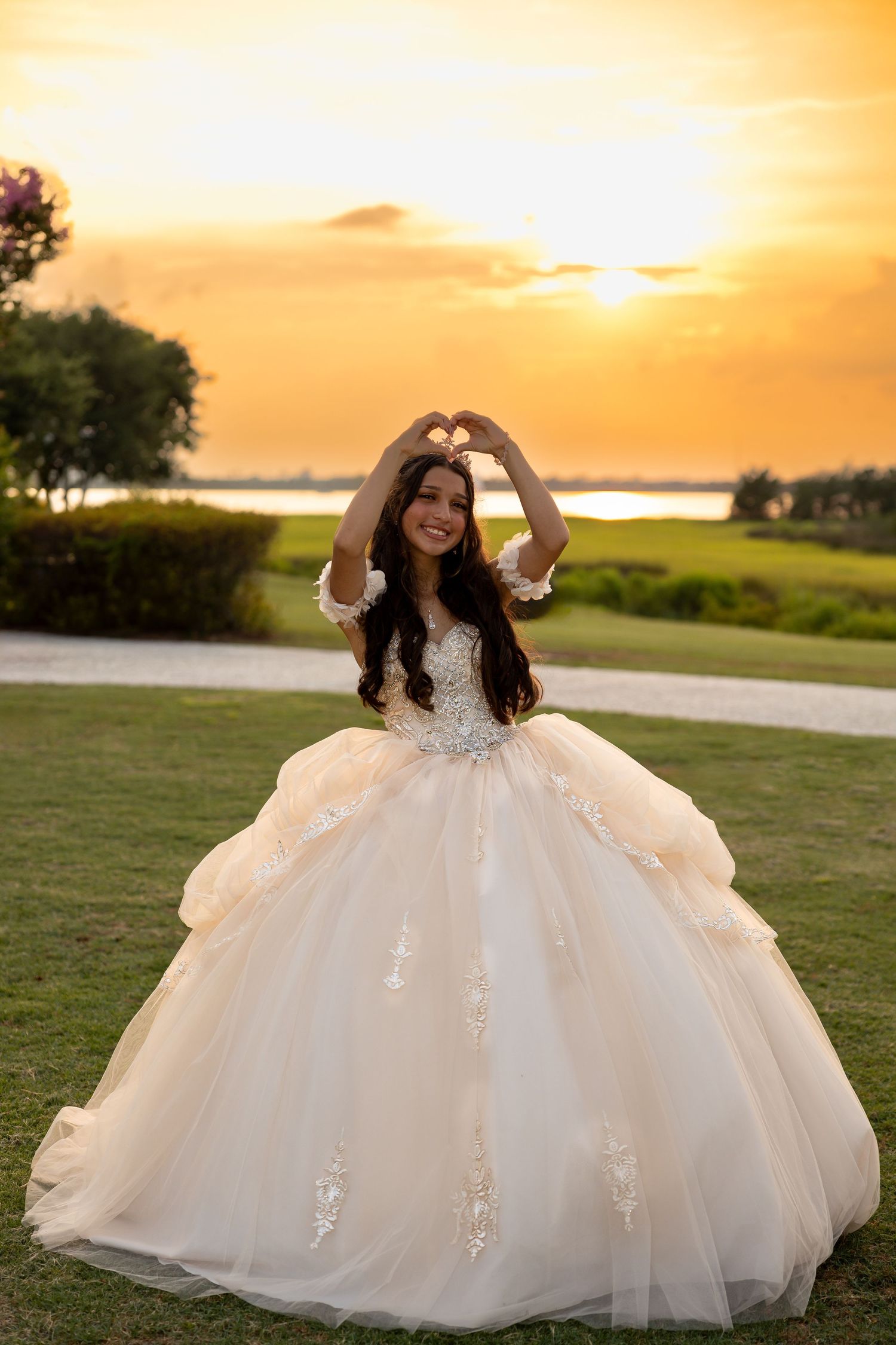 A flowing white ballgown dress photographed during golden hour sunset against a scenic landscape.