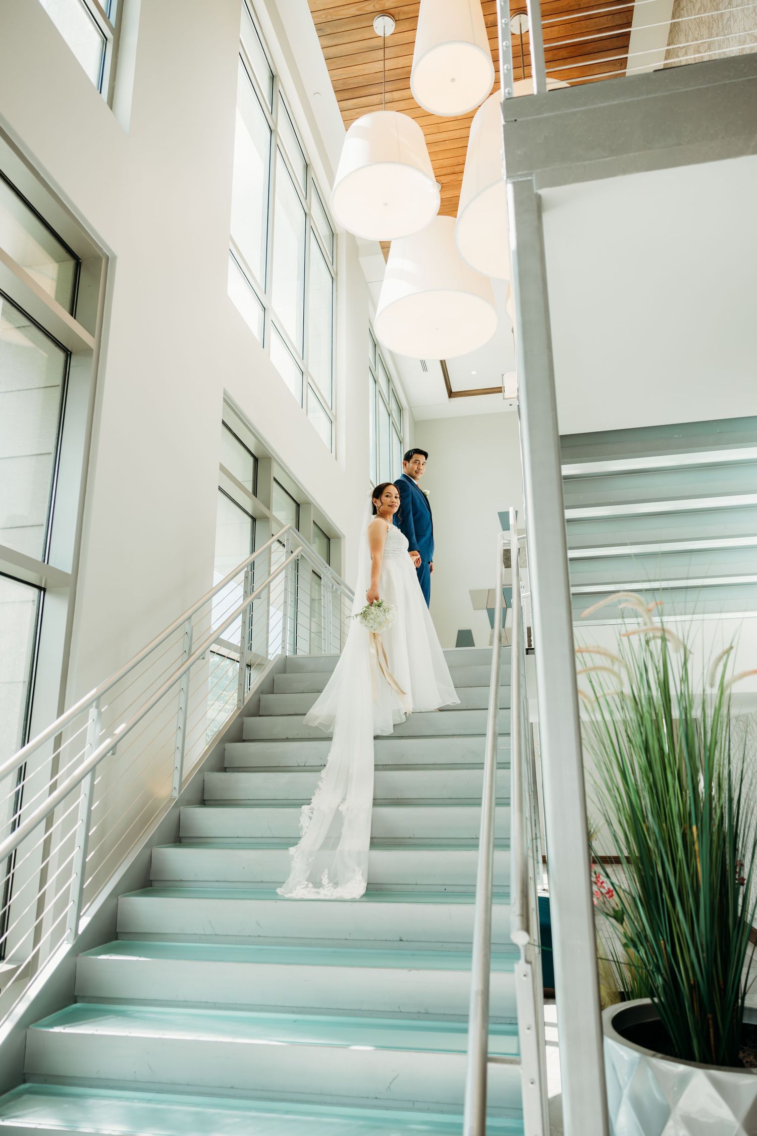 Wedding couple captured in series of romantic poses on modern blue-tinted staircase.