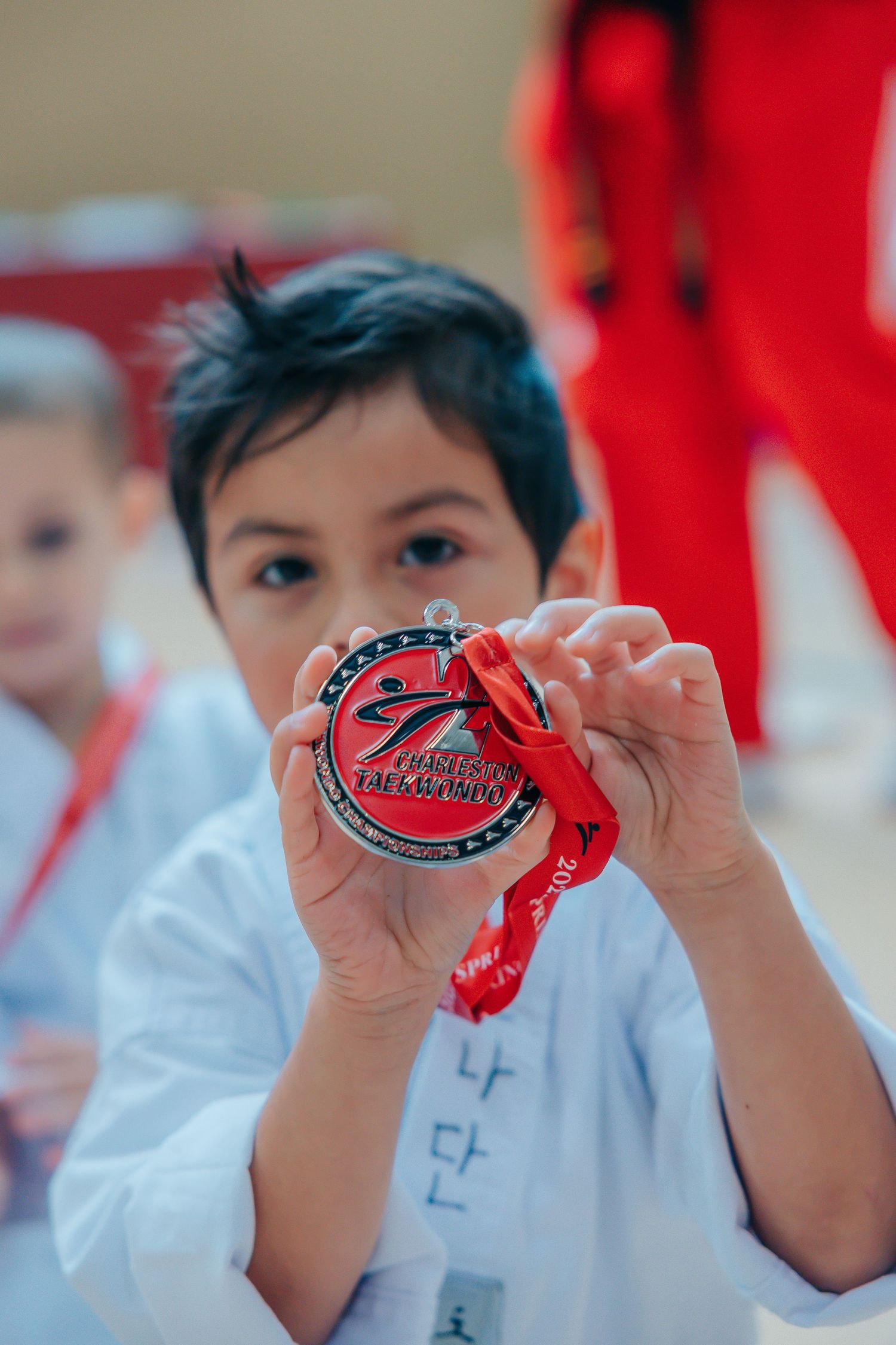 Close-up of red medals being displayed against a bright red background.
