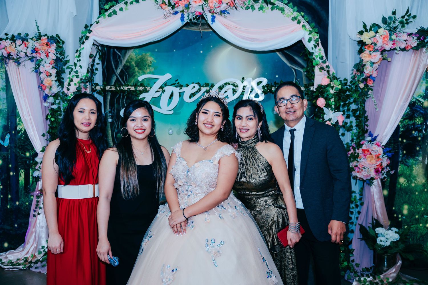 Reception venue features enchanted garden theme with blue lighting and floral decorations.
