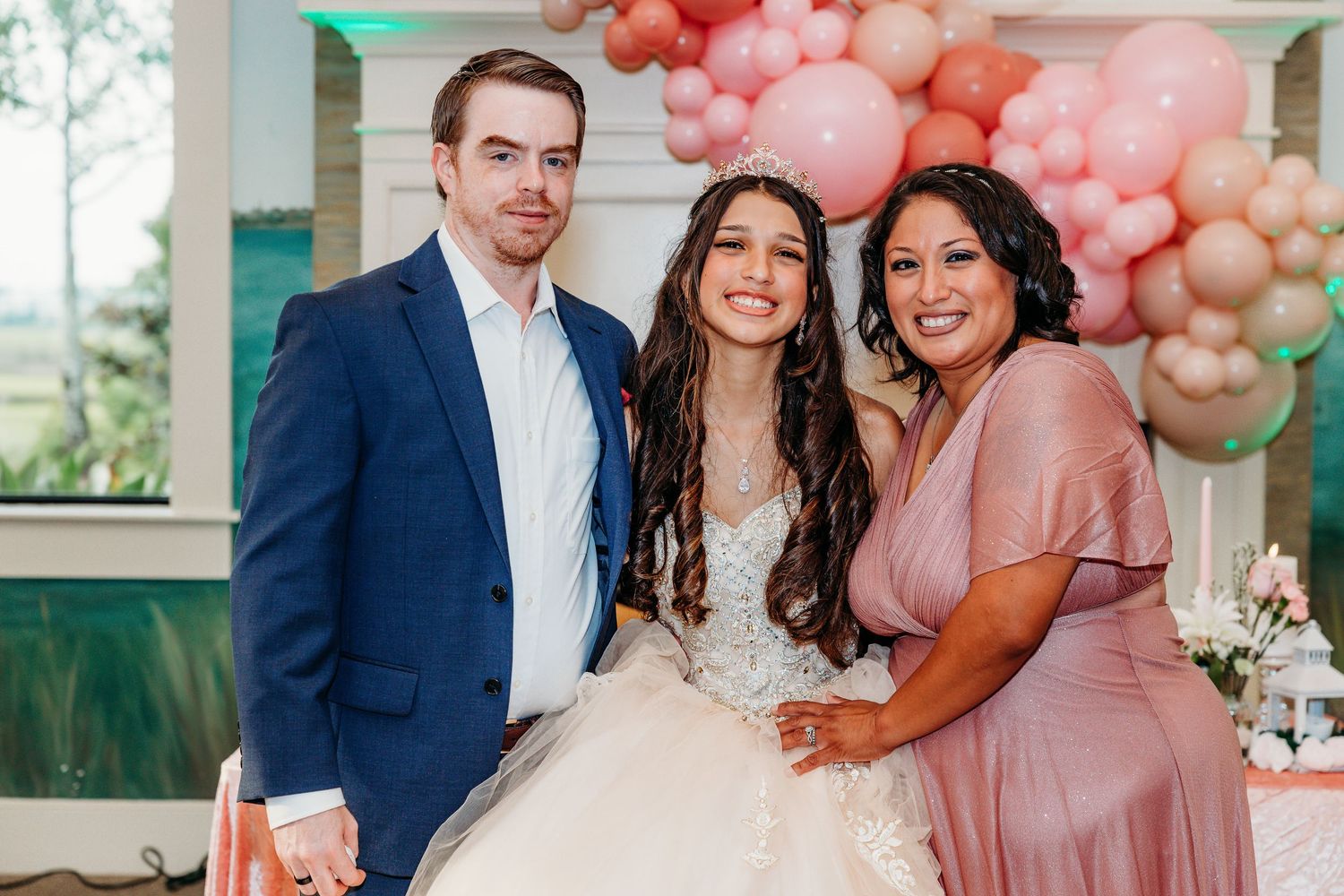 Wedding celebration with pink balloon arch and decorative elements in an indoor venue.