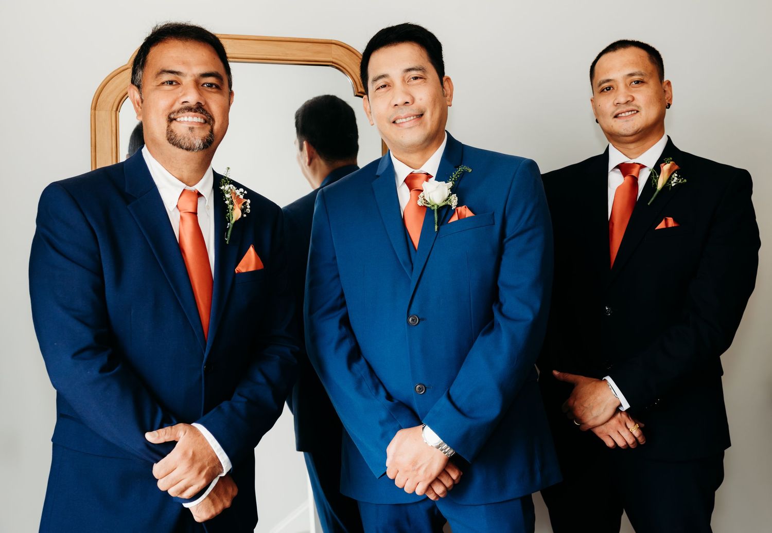 Group photo of business professionals in matching navy suits with red ties and pocket squares.