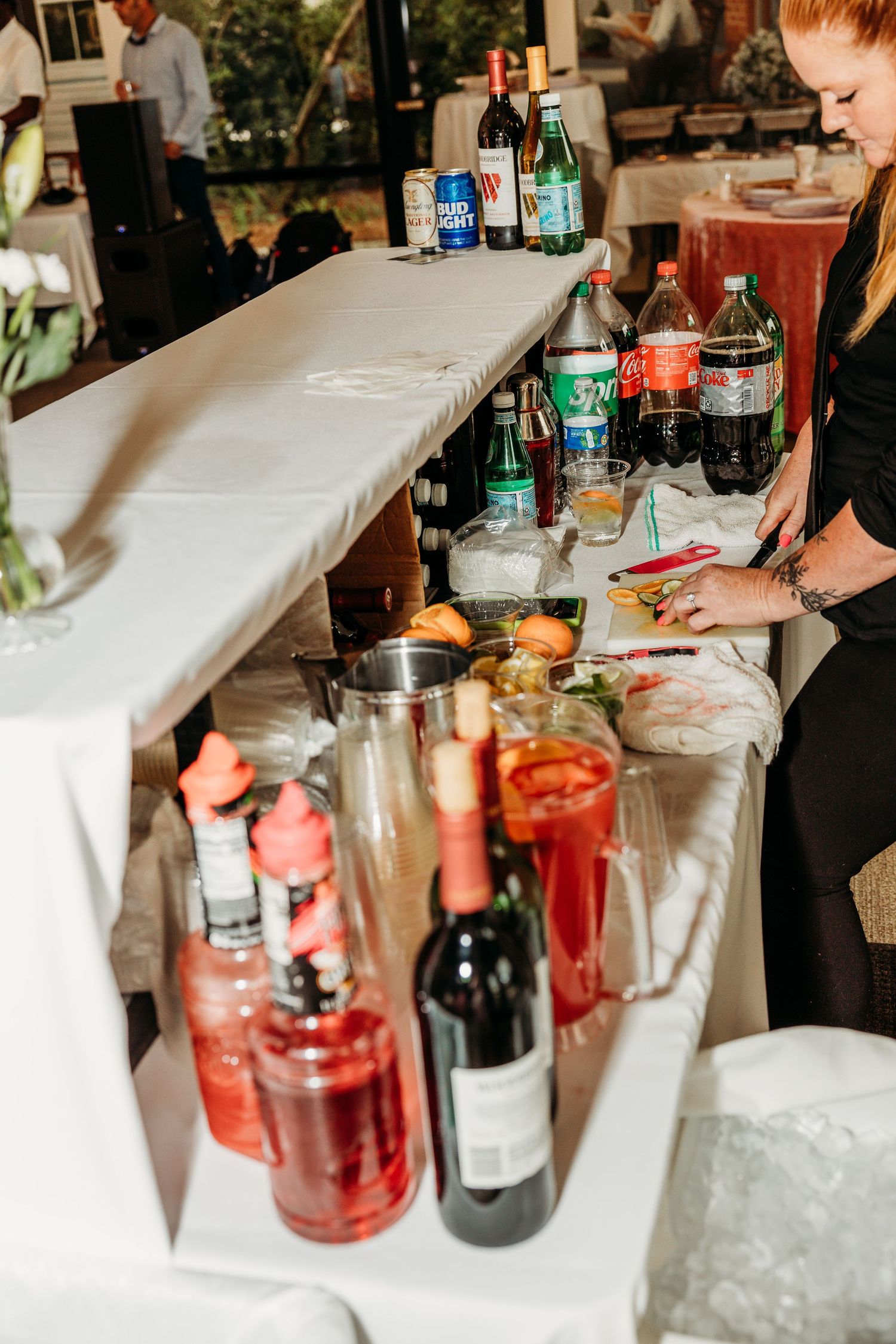 Bar setup at a wedding reception with colorful cocktails and beverages on display.