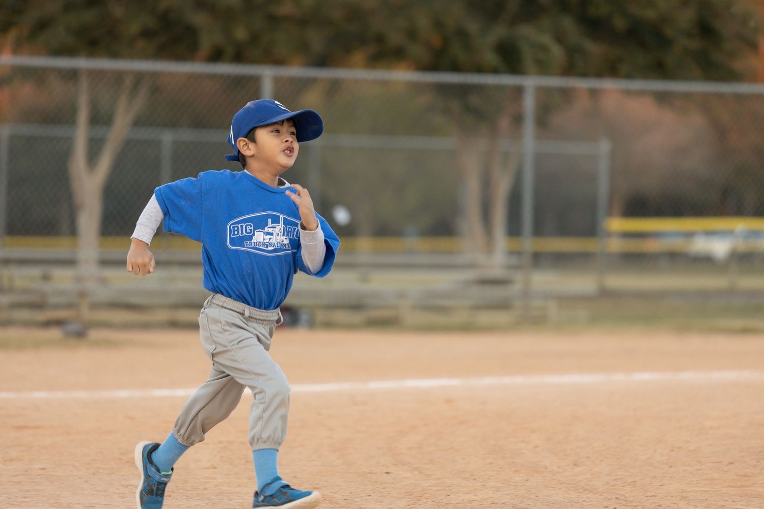 Youth baseball players in action on a dusty baseball diamond.