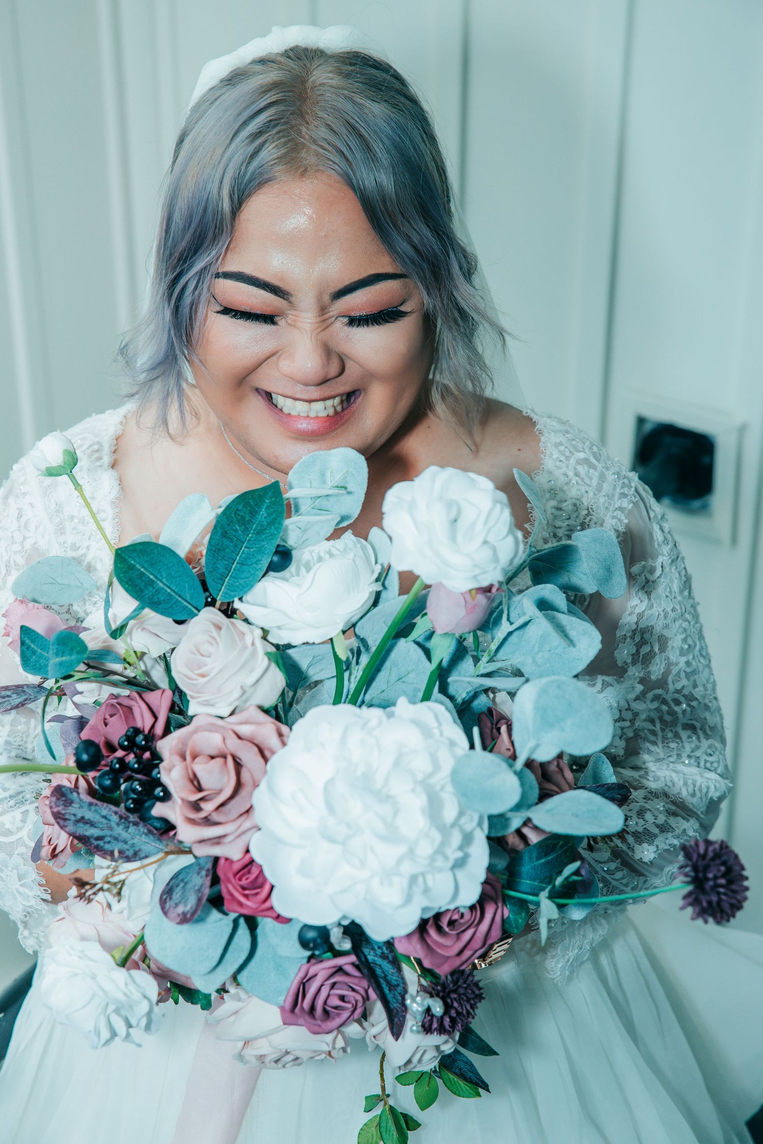 Close up shots of bridal bouquet featuring white and mauve roses with eucalyptus greenery.