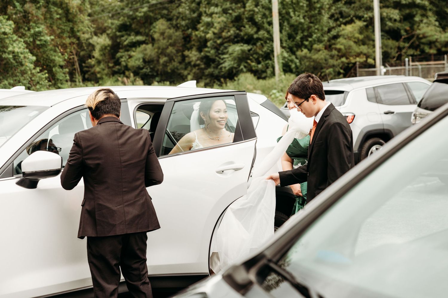 Wedding party members walking through a parking lot on their way to the ceremony.