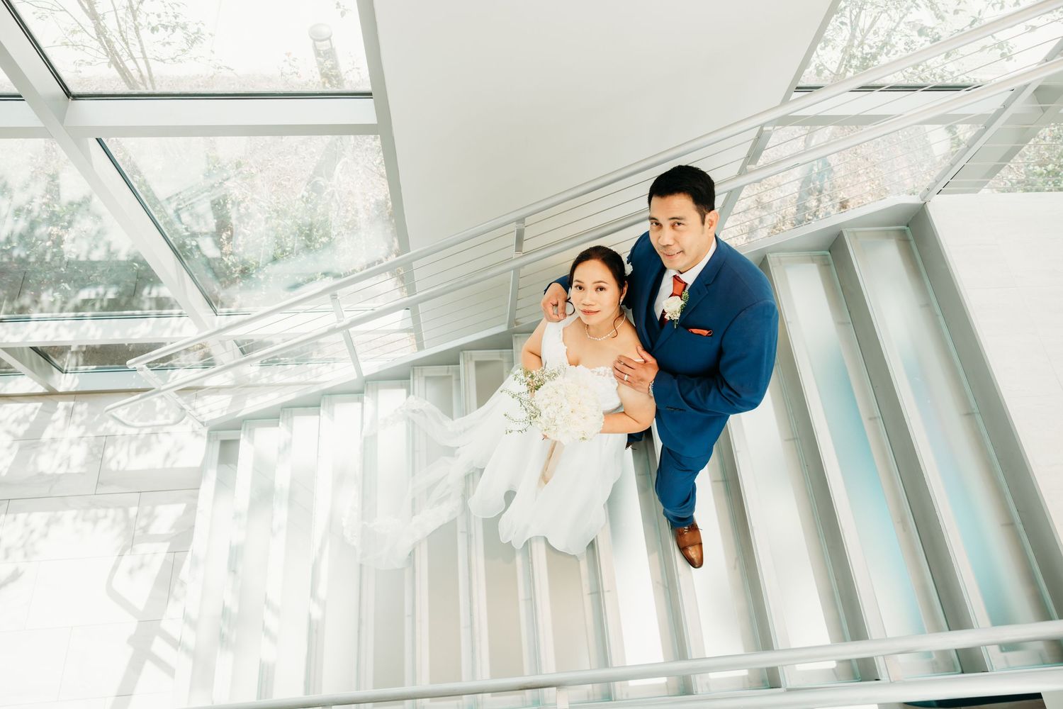 Light-filled modern stairwell creates dramatic setting for wedding photography.