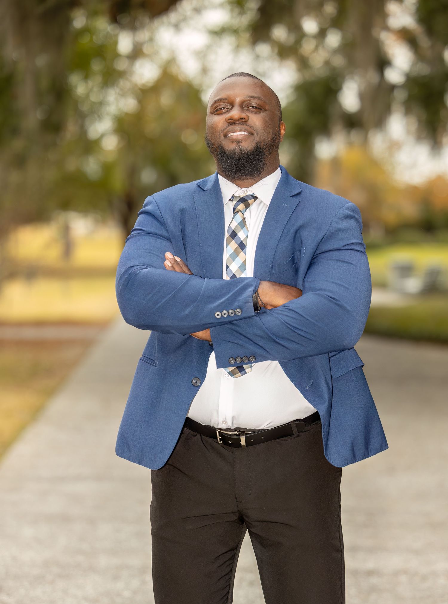 Professional headshots showing person in blue blazer and plaid tie against outdoor setting.