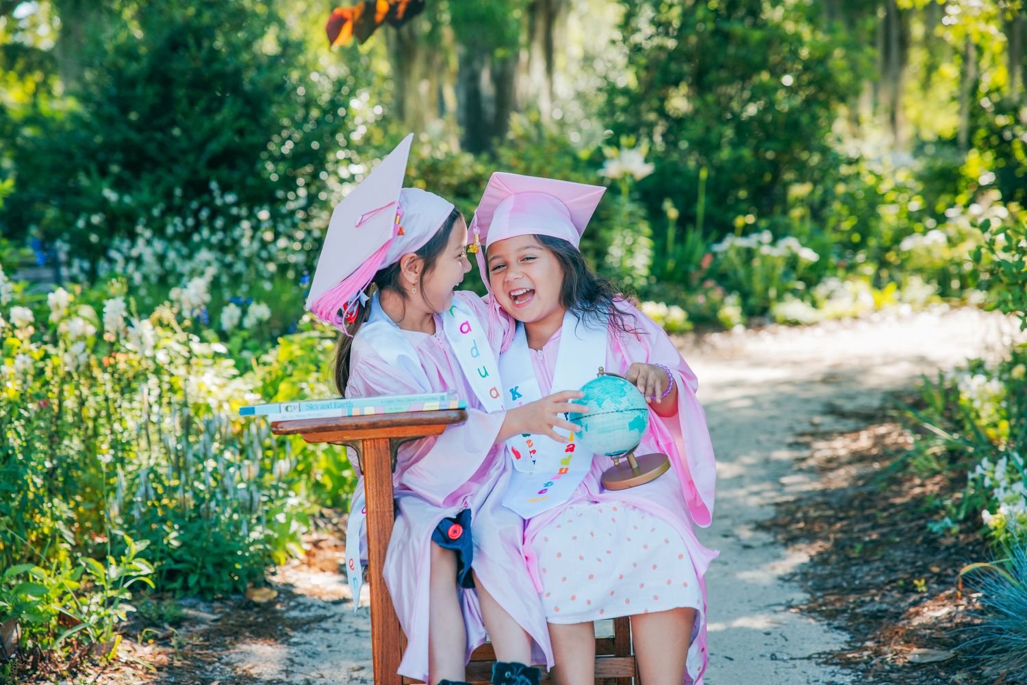 A graduation celebration captured in a lush garden setting with wooden benches.
