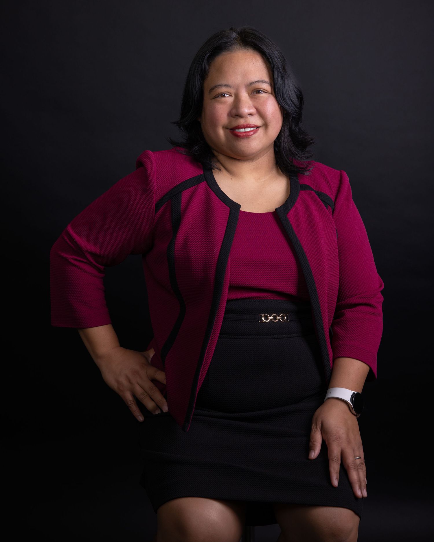 Business portrait series against black backdrop featuring magenta blazer and natural poses.