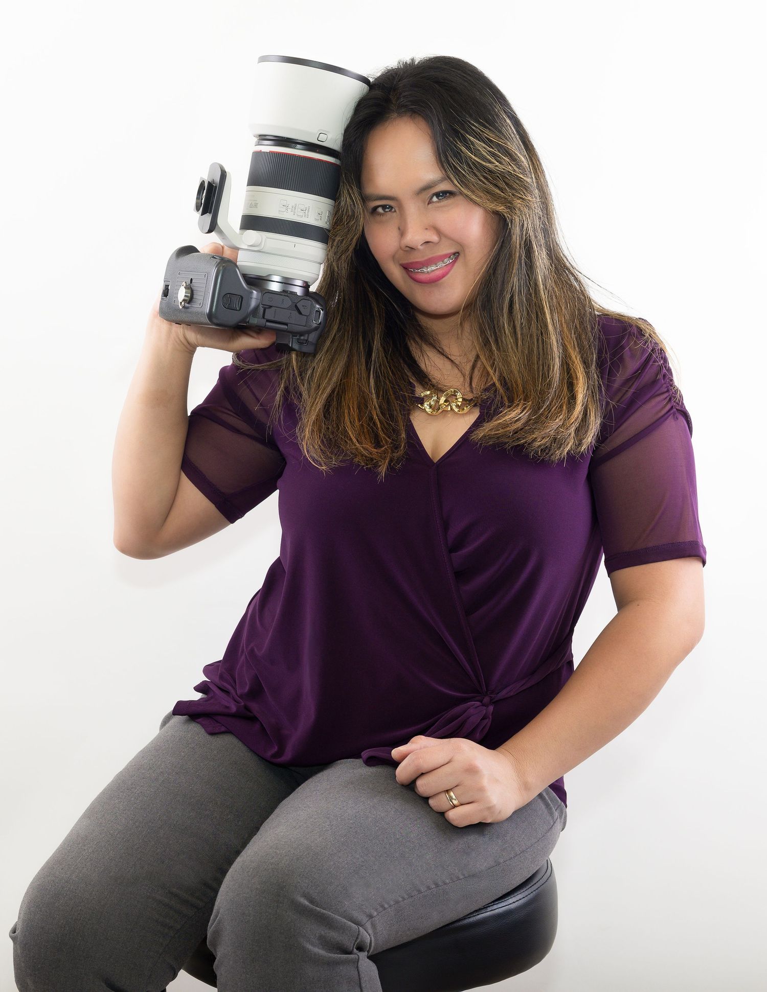 A person in a purple top and gray pants poses casually in three different positions against a white background.