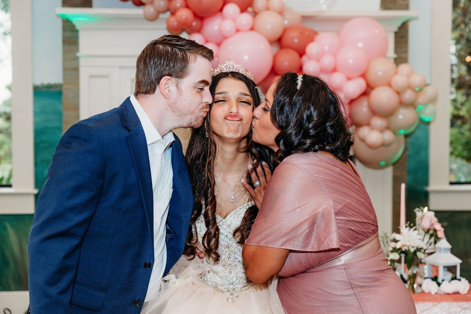Wedding celebration with pink balloon arch and decorations in an elegant outdoor setting.