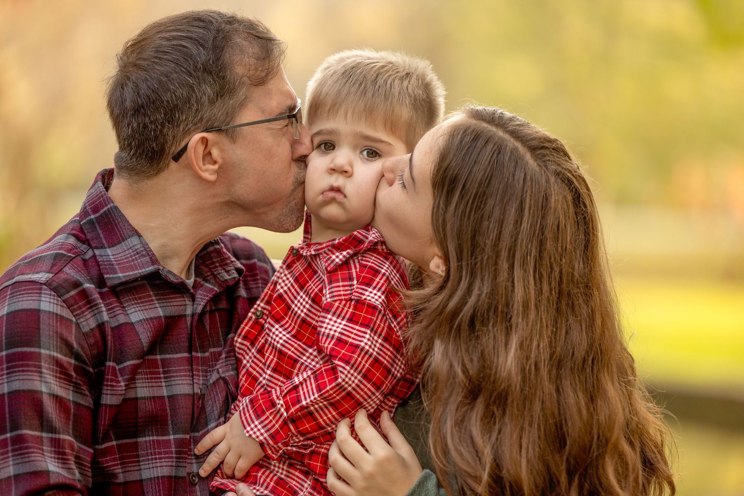 Sweet candid moments captured of a family embracing outdoors in autumn.