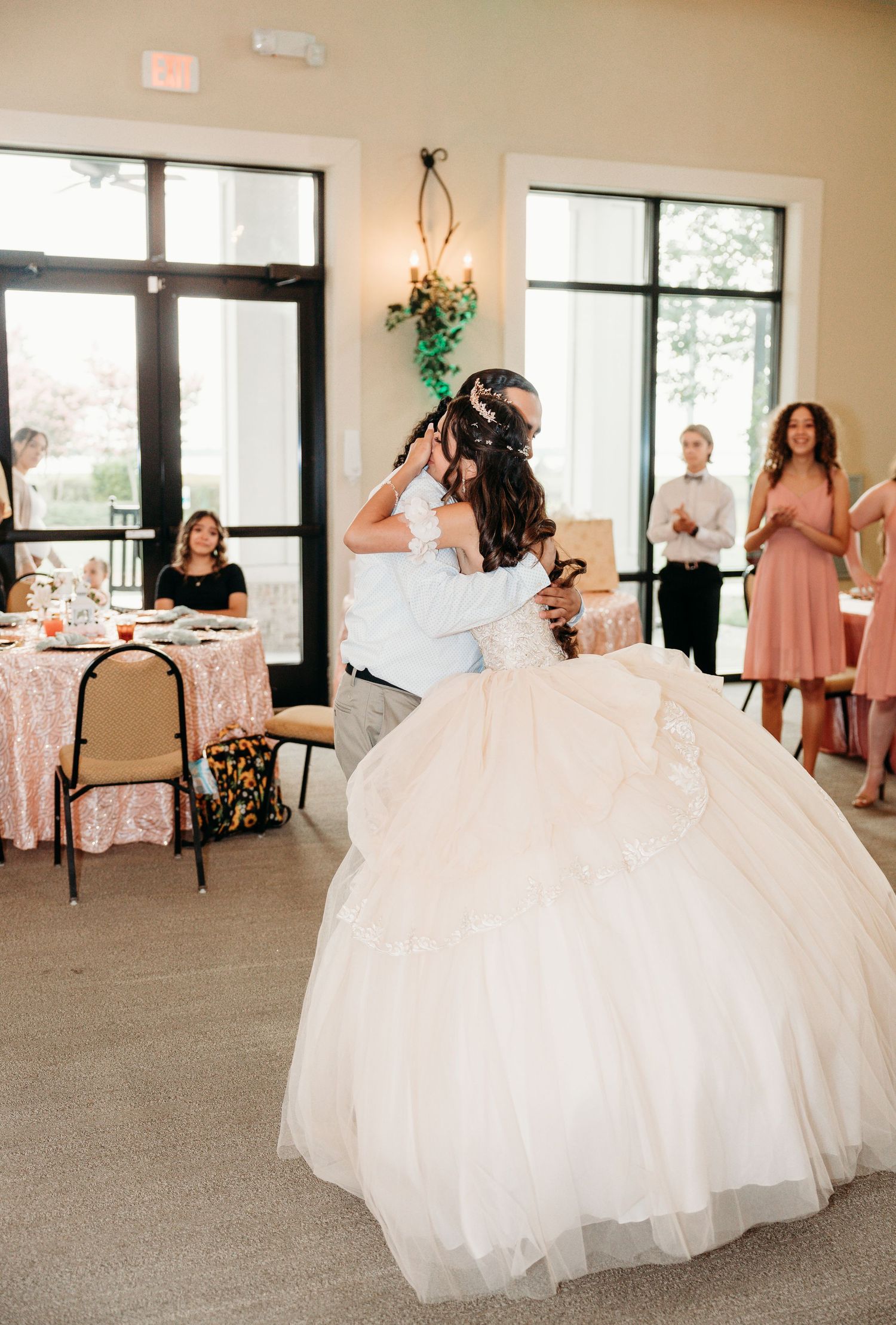 Festive indoor celebration with pink balloon arch decorations and dancing.