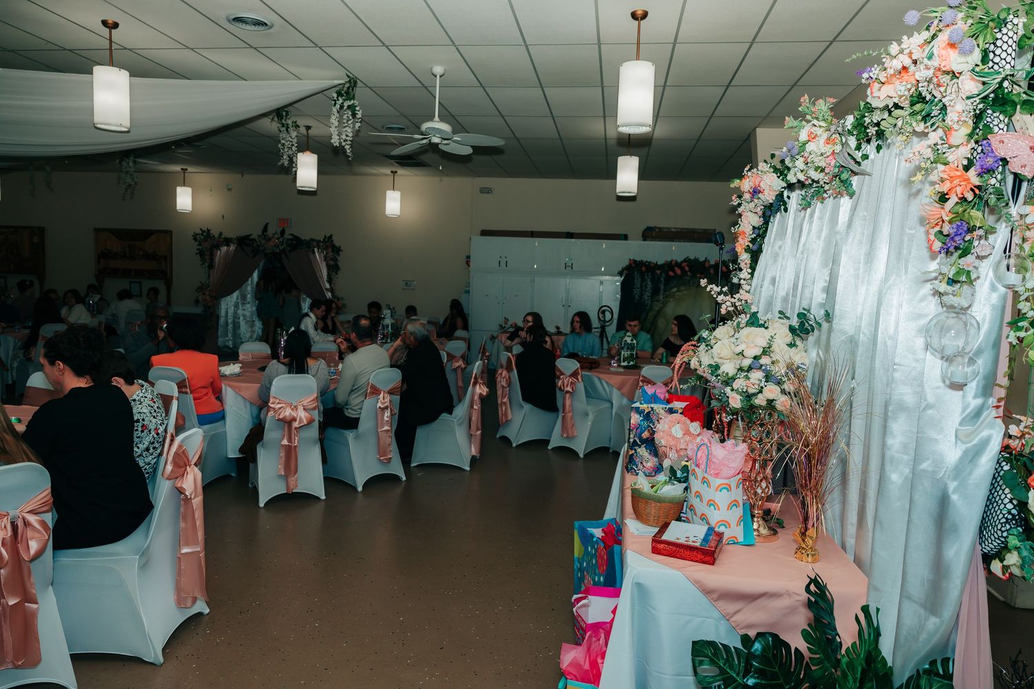 Wedding reception venue decorated with white chairs and floral arrangements for an elegant celebration.