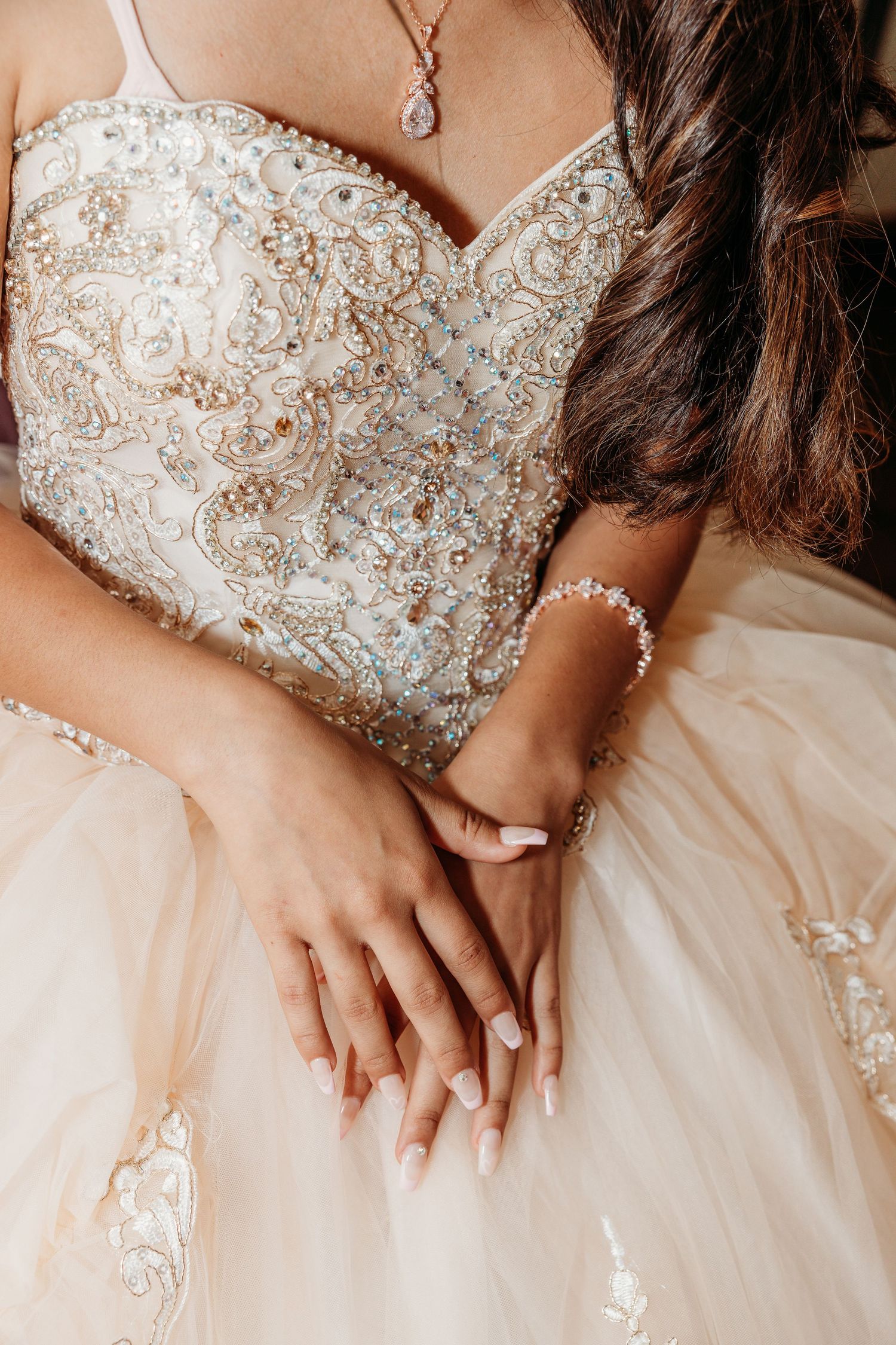 Close-up detail of an ornate beaded bodice on a white wedding gown.