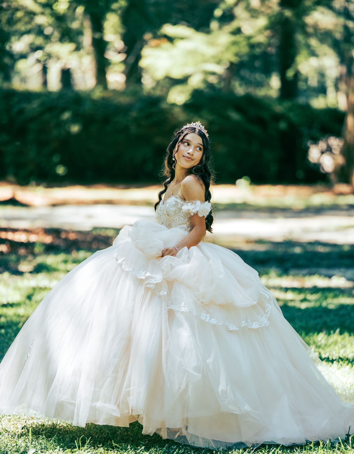 A series of bridal portraits featuring a flowing white ballgown dress in a sunlit garden.