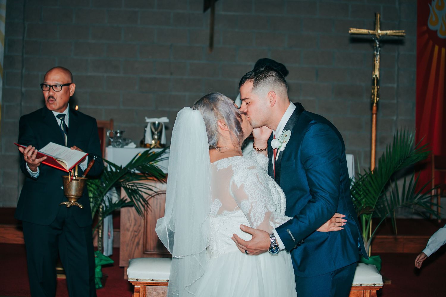 Wedding ceremony taking place in a traditional church sanctuary with red carpet.