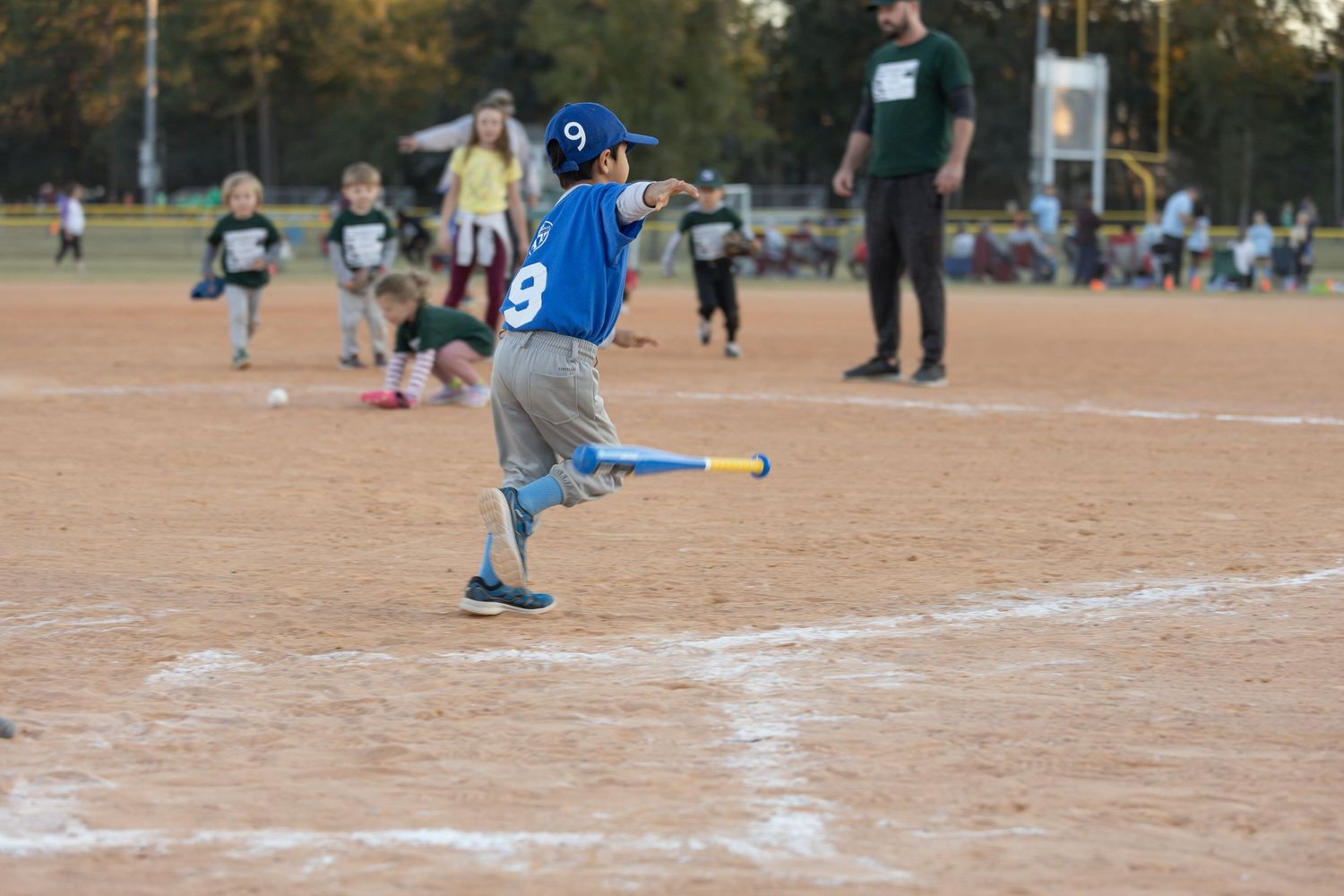 Baseball players practicing and playing on a sunny field.