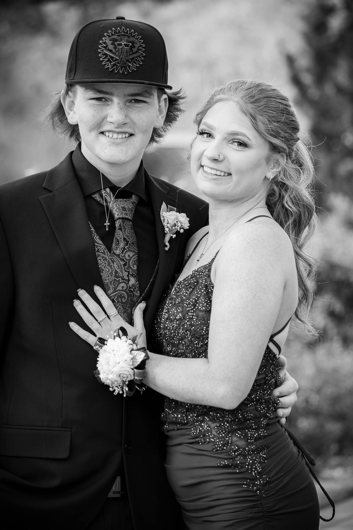 Black and white formal portraits showing a couple in elegant attire with corsage at special event.