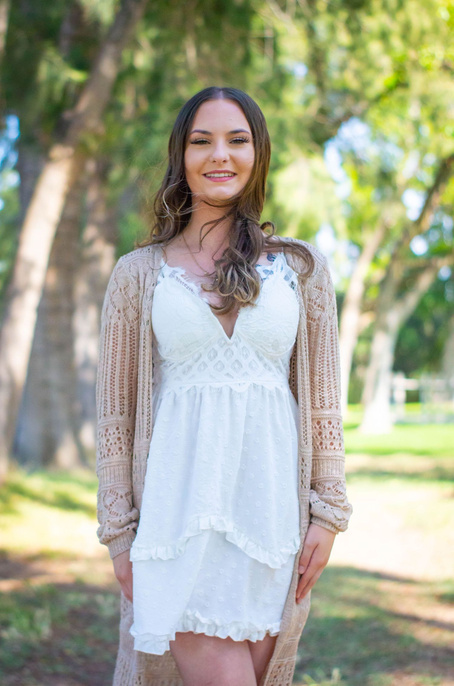 Outdoor nature shoot featuring lace white top and beige cardigan combination.