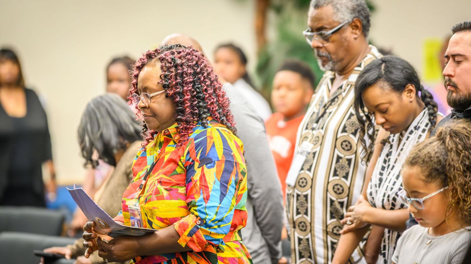 Church members dressed in colorful attire participate in worship service.