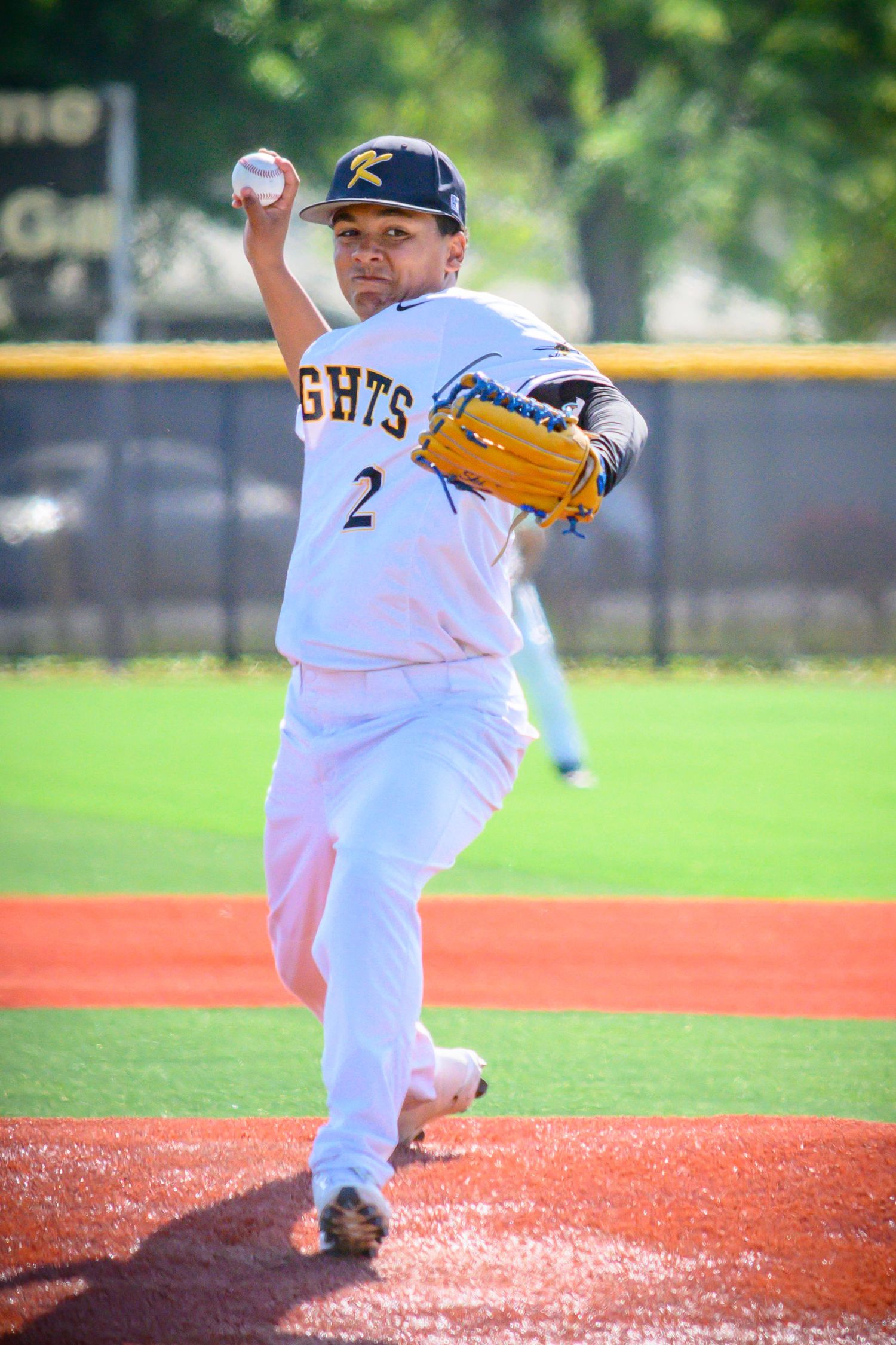 Baseball pitcher in white uniform with number 2 throws from the mound during a game.