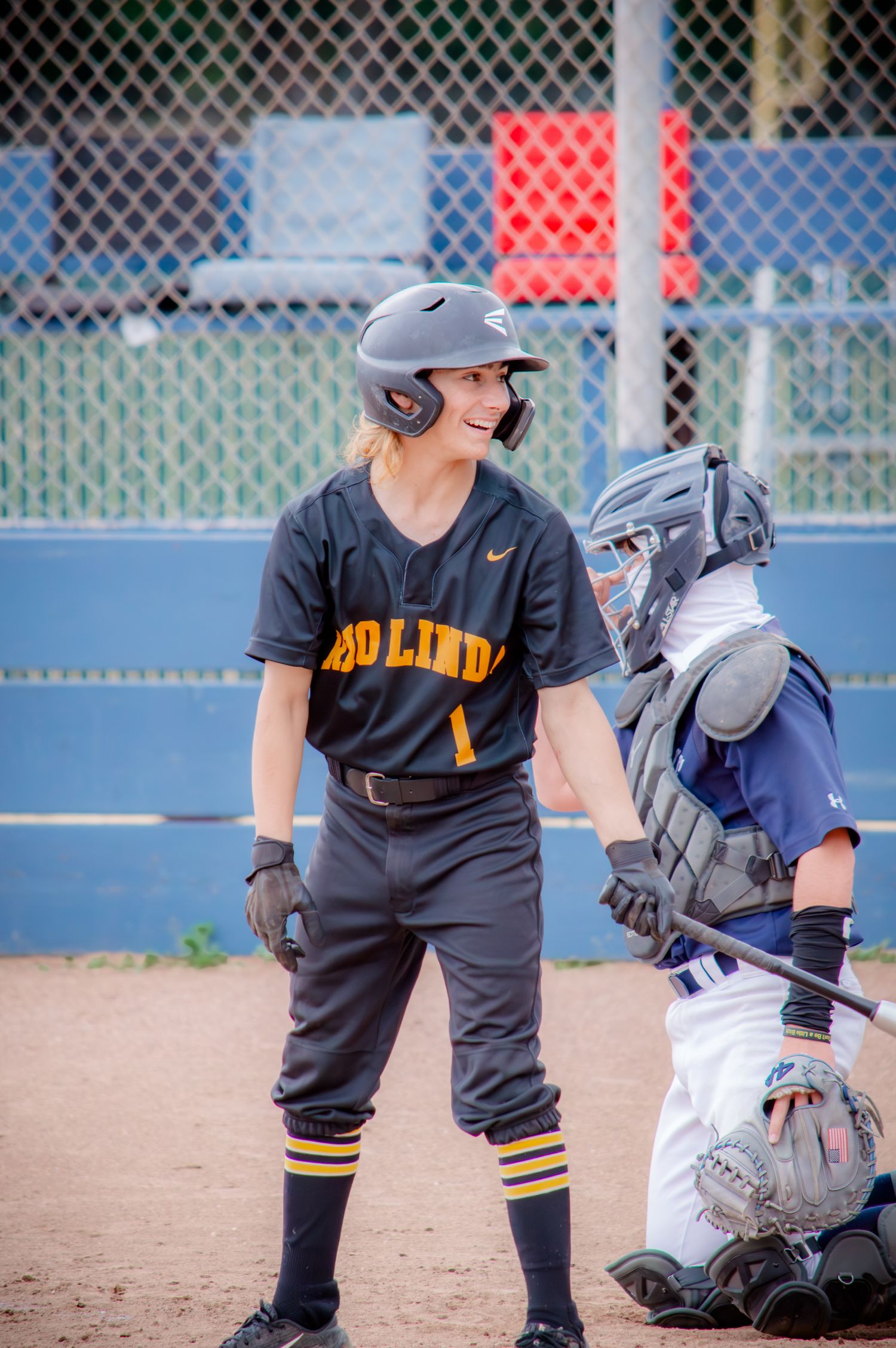 Baseball players in action near home plate during competitive game.