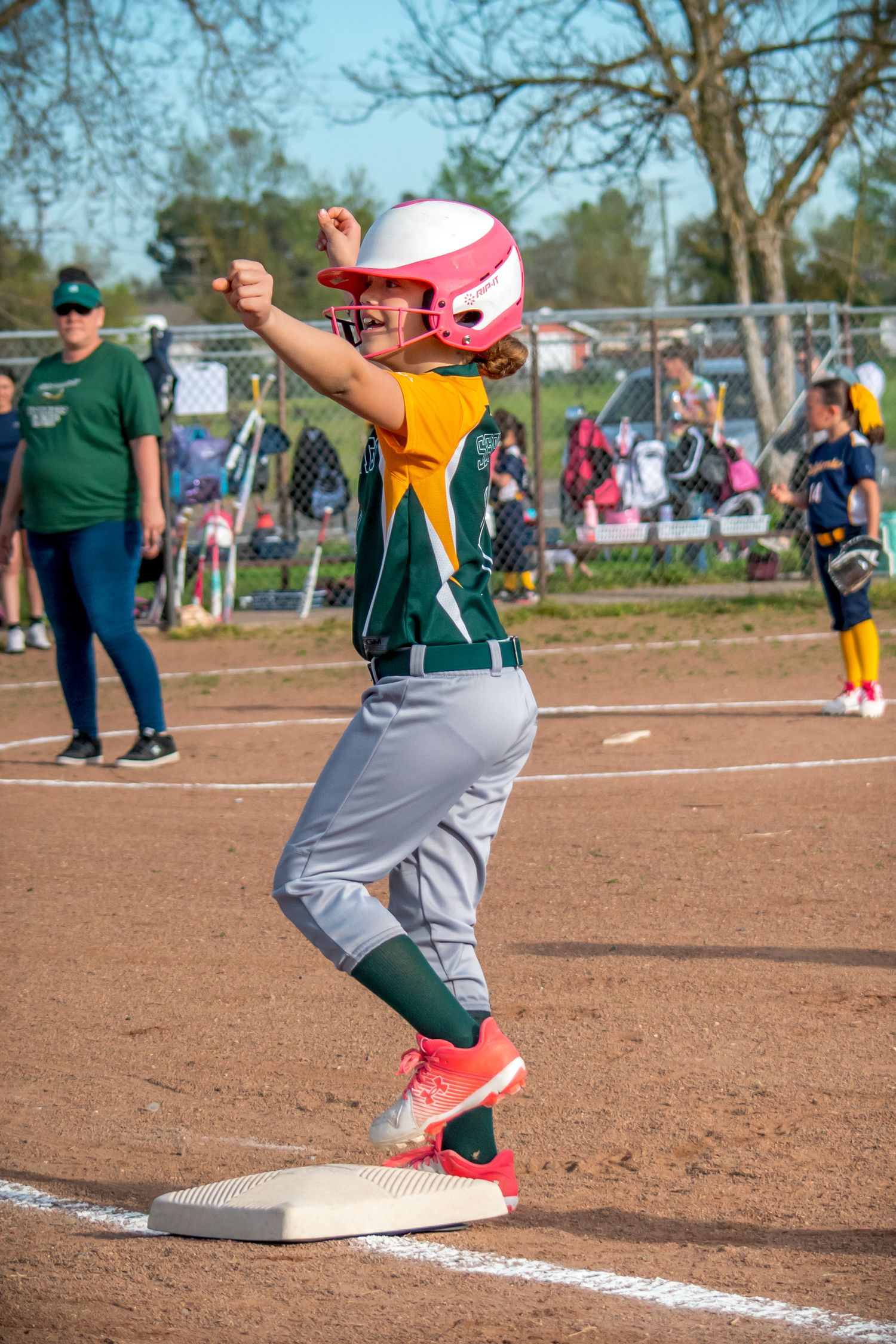 Softball player's feet and cleats stepping on home plate during a game.