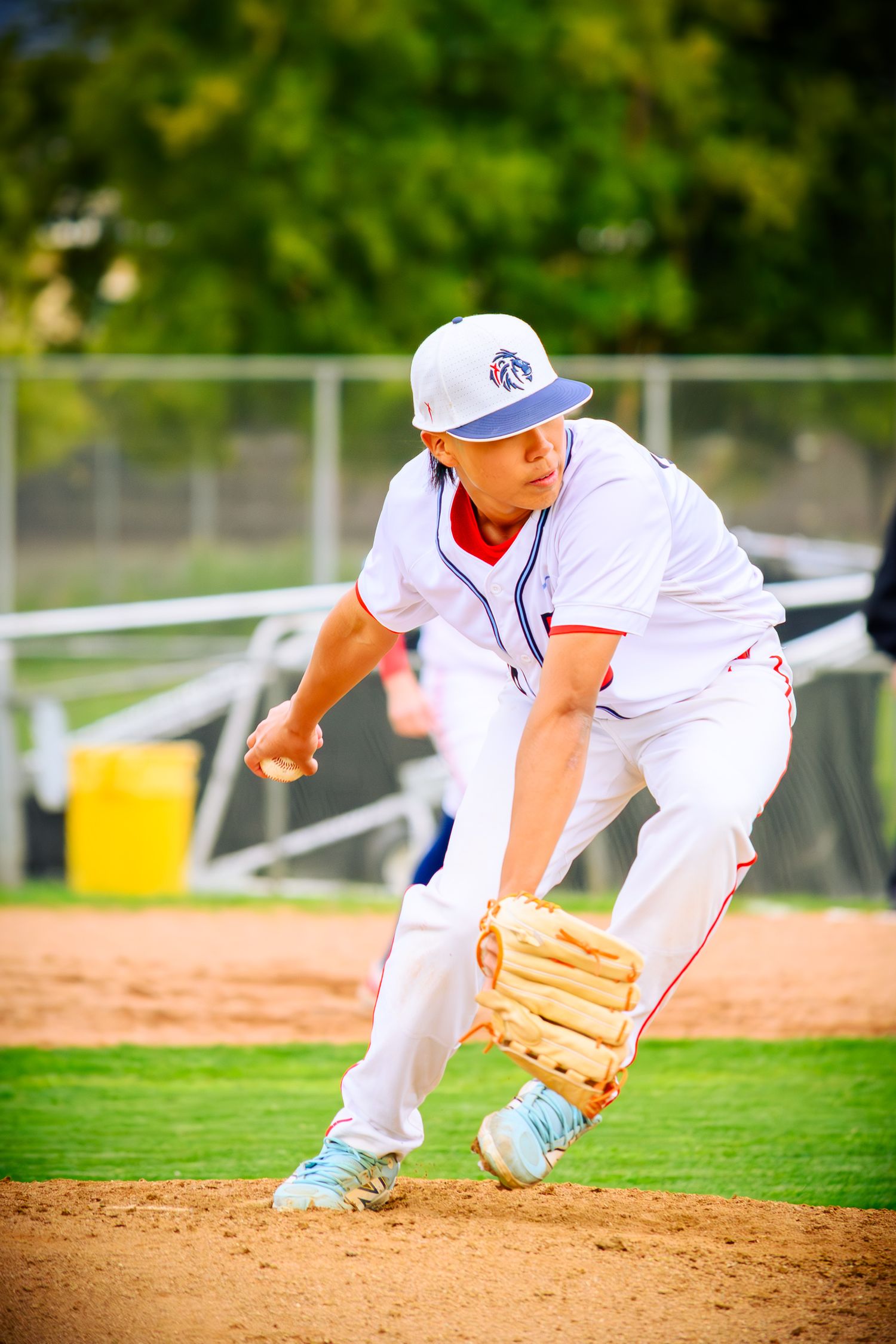 Baseball player diving and fielding ground ball on baseball diamond.