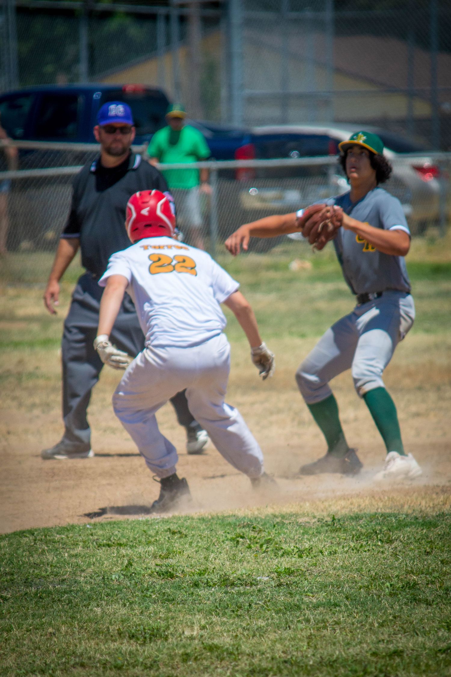 Baseball players diving and sliding on grass field during intense game action.