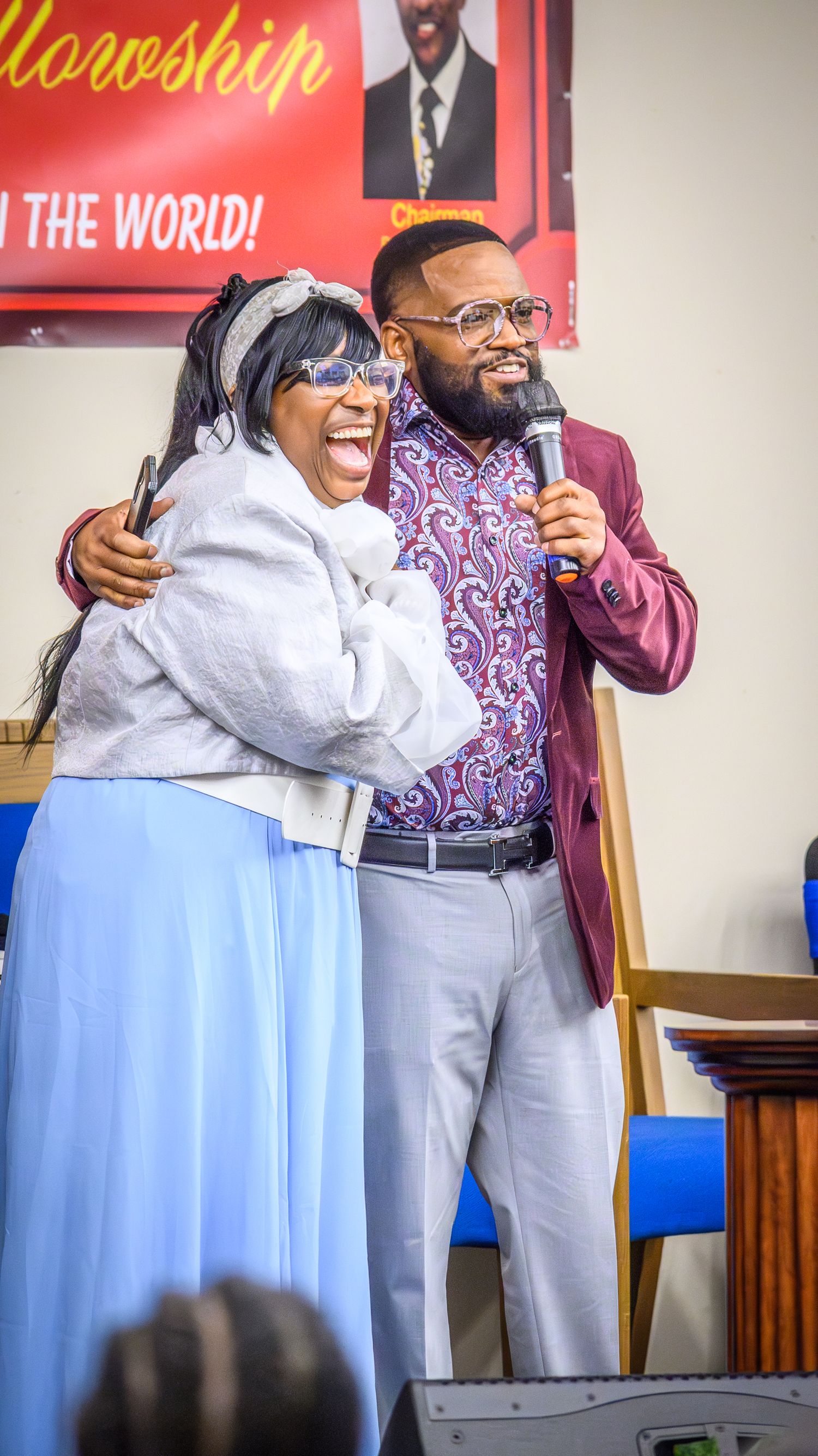 Joyful expressions and embraces shared between people during a church gathering.