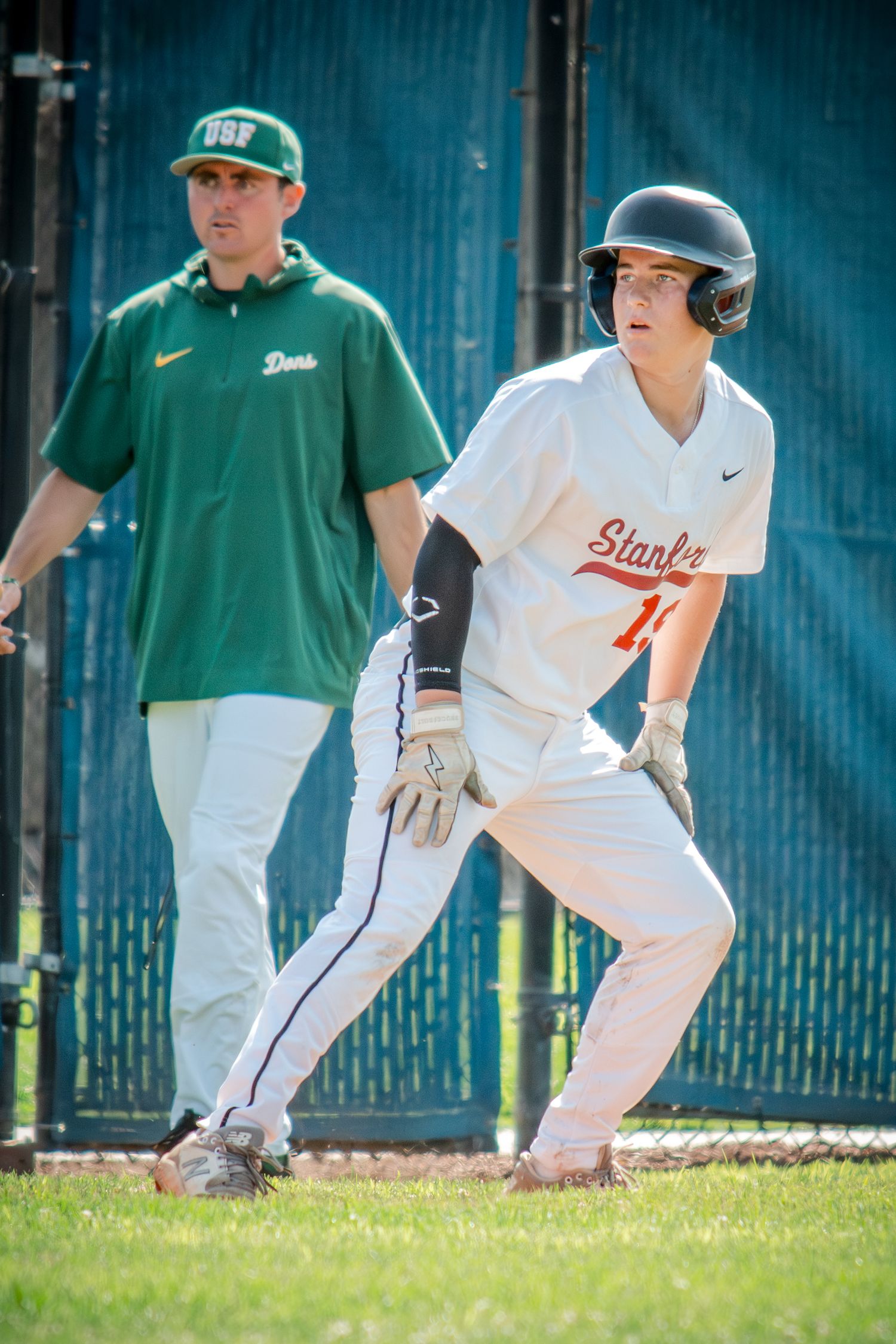 Sequence of four baseball players in green and white uniforms practicing base running during a training session.