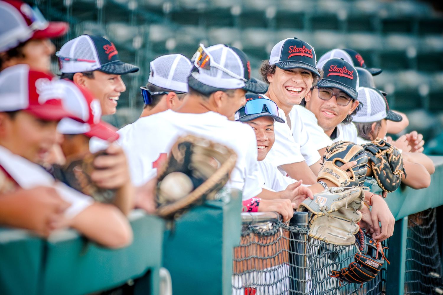 Baseball players and coaches watching intently from dugout during game.