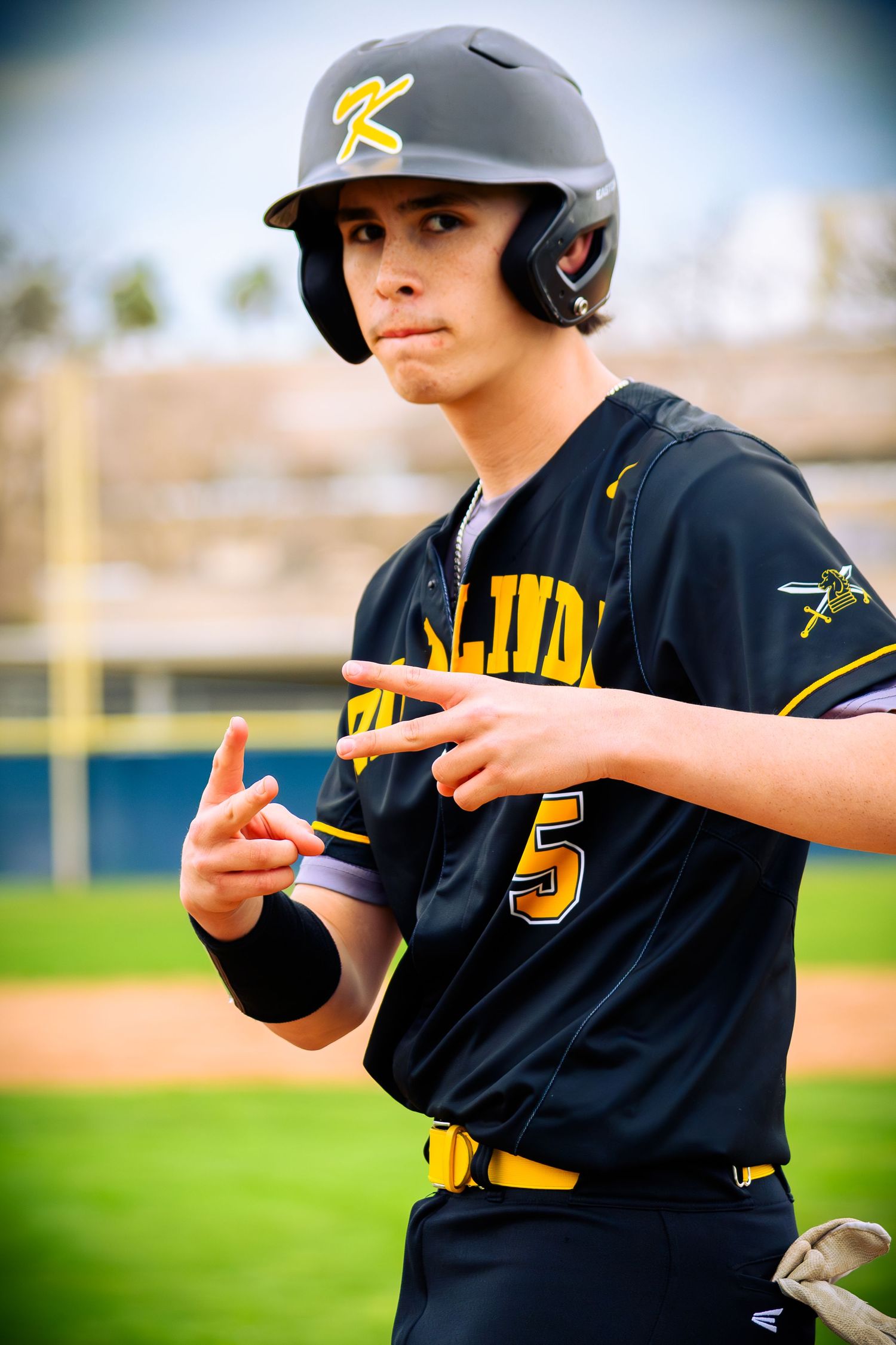 Baseball player in black and yellow uniform demonstrating batting stance sequence on field.