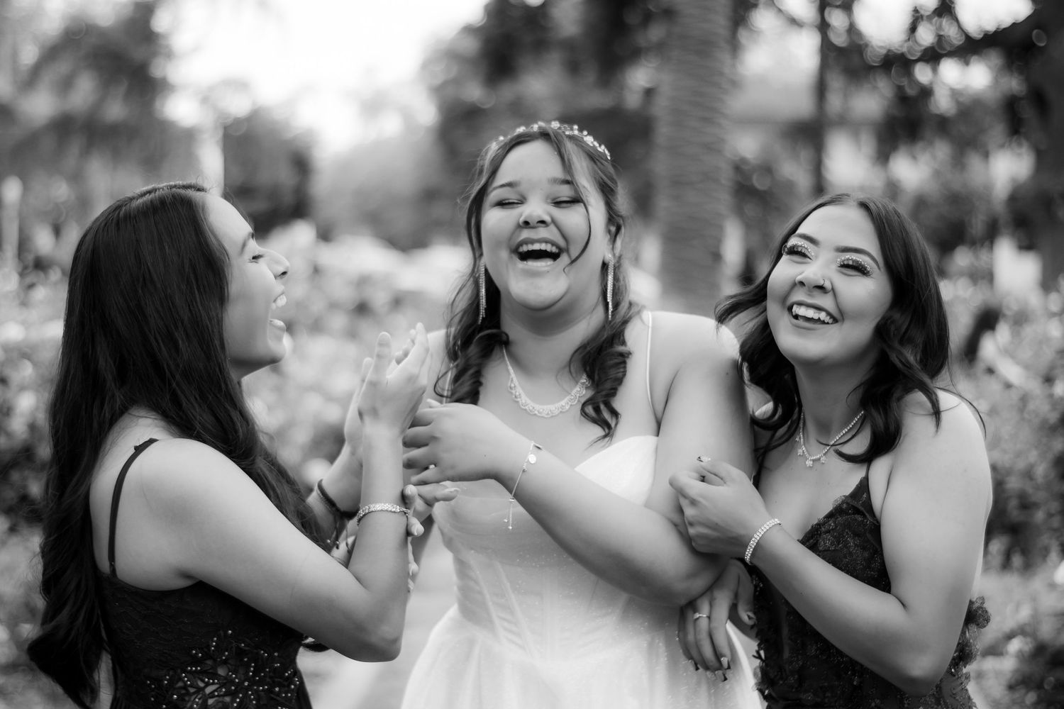 Three friends share a candid laughing moment in black and white photography.