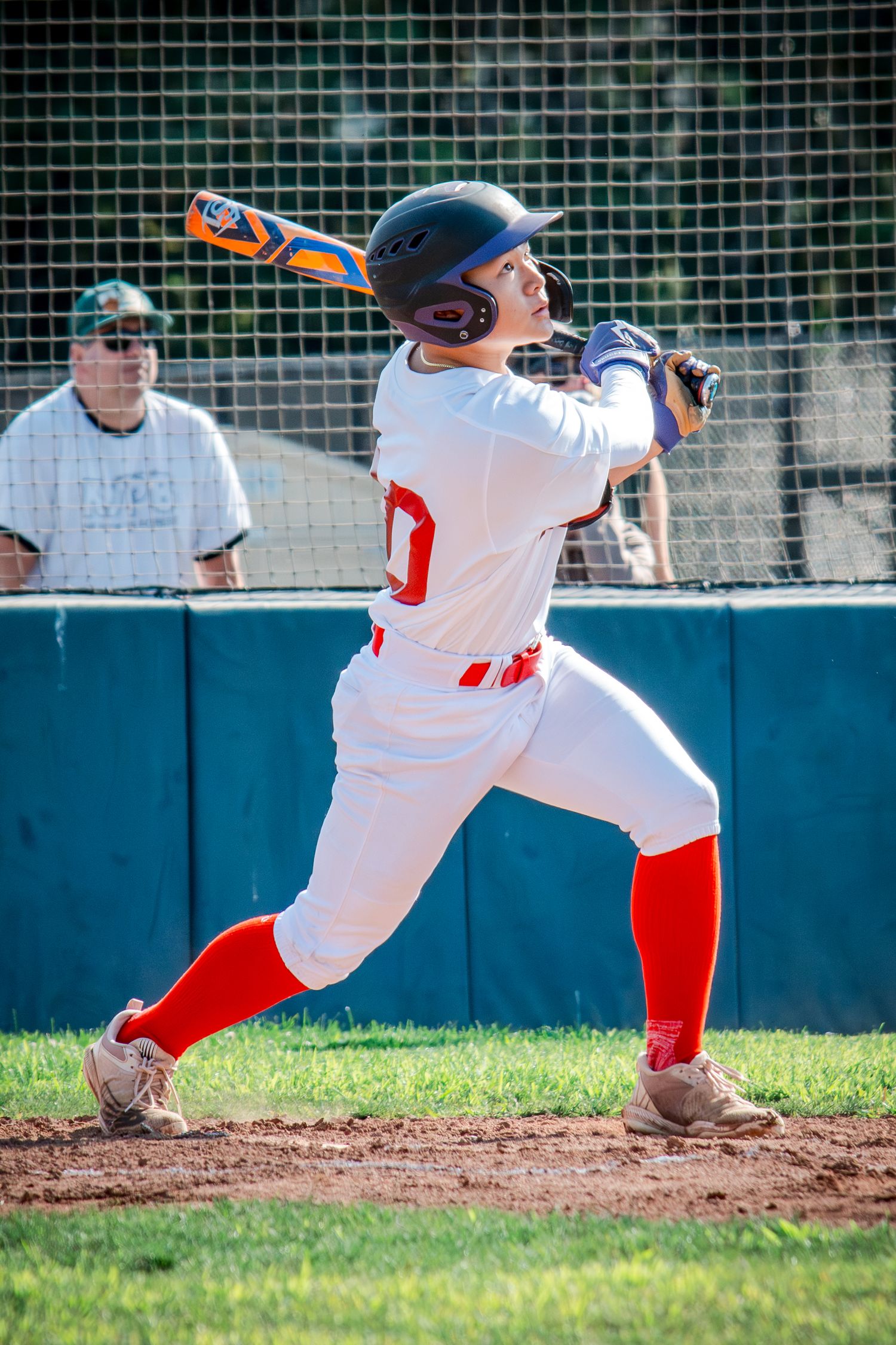 Baseball player executing batting sequence in white and red uniform on field.
