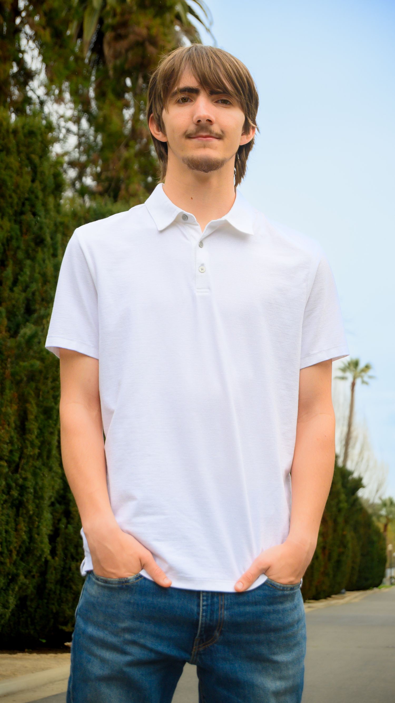 Person in casual white polo shirt and blue jeans poses against outdoor background in multiple angles.