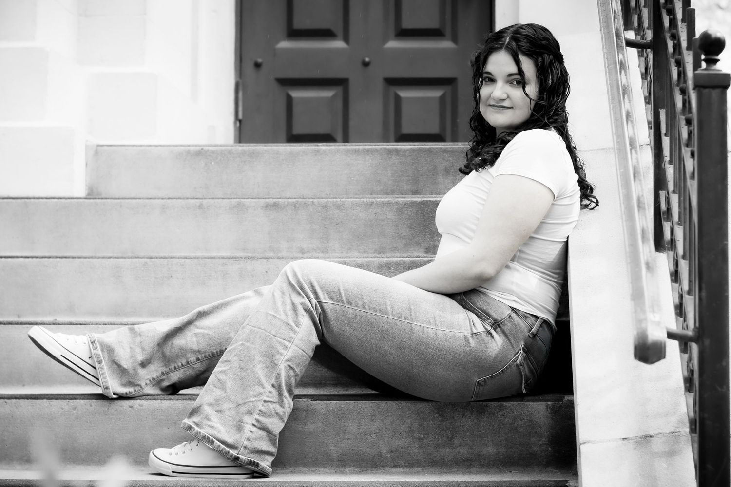 Black and white portrait on steps in casual attire.