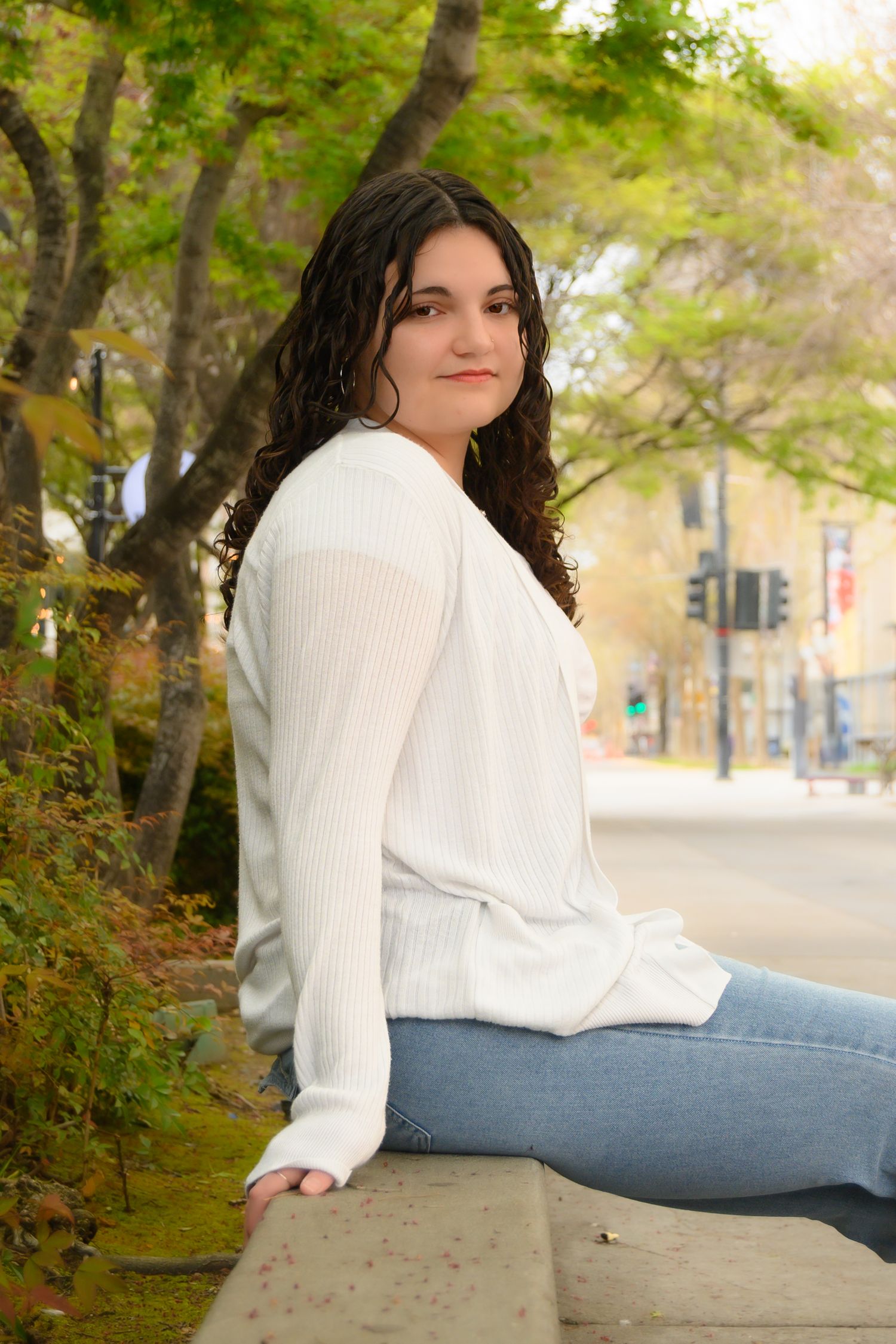 A series of casual outdoor portraits showing someone in a white sweater and jeans sitting on a stone wall with autumn foliage.