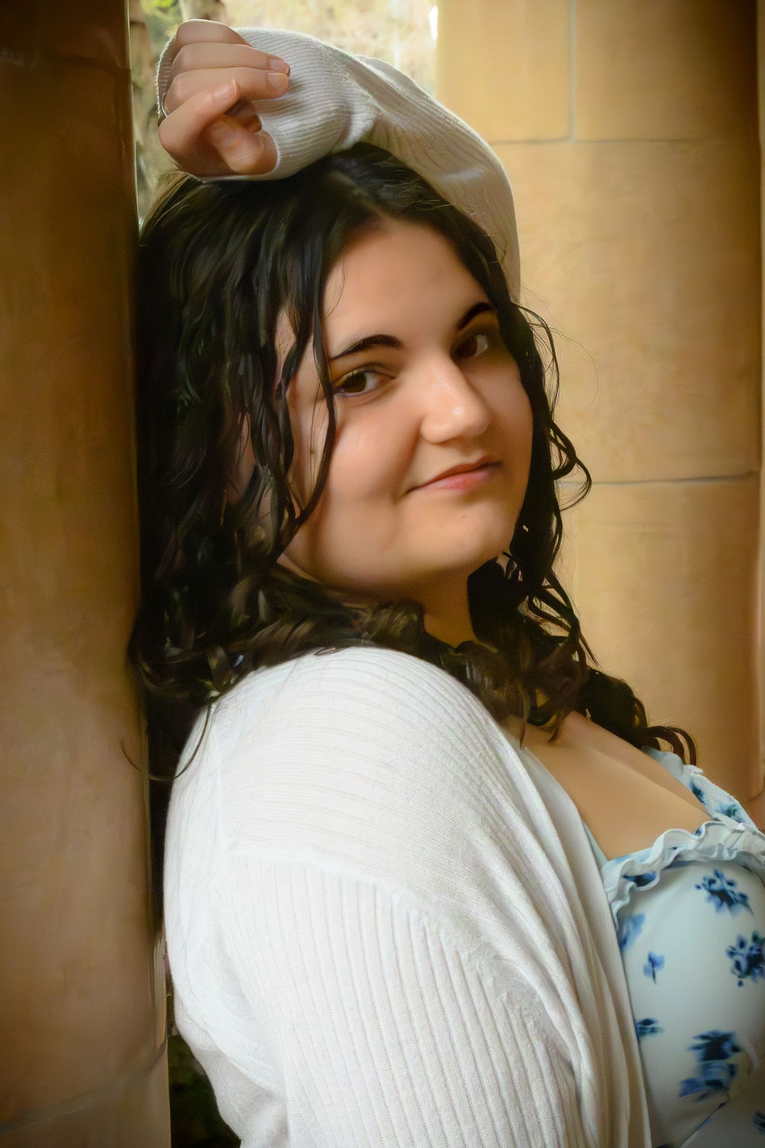 Indoor portrait wearing white cardigan and floral print.