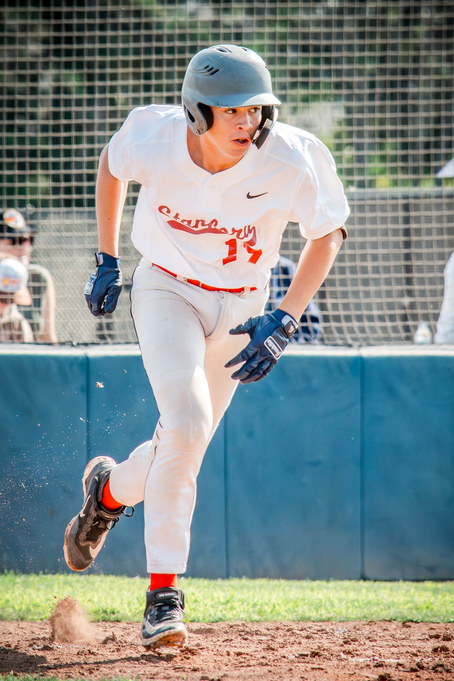 Close-up action shots show a baseball player running and sliding feet first into a base during a game.