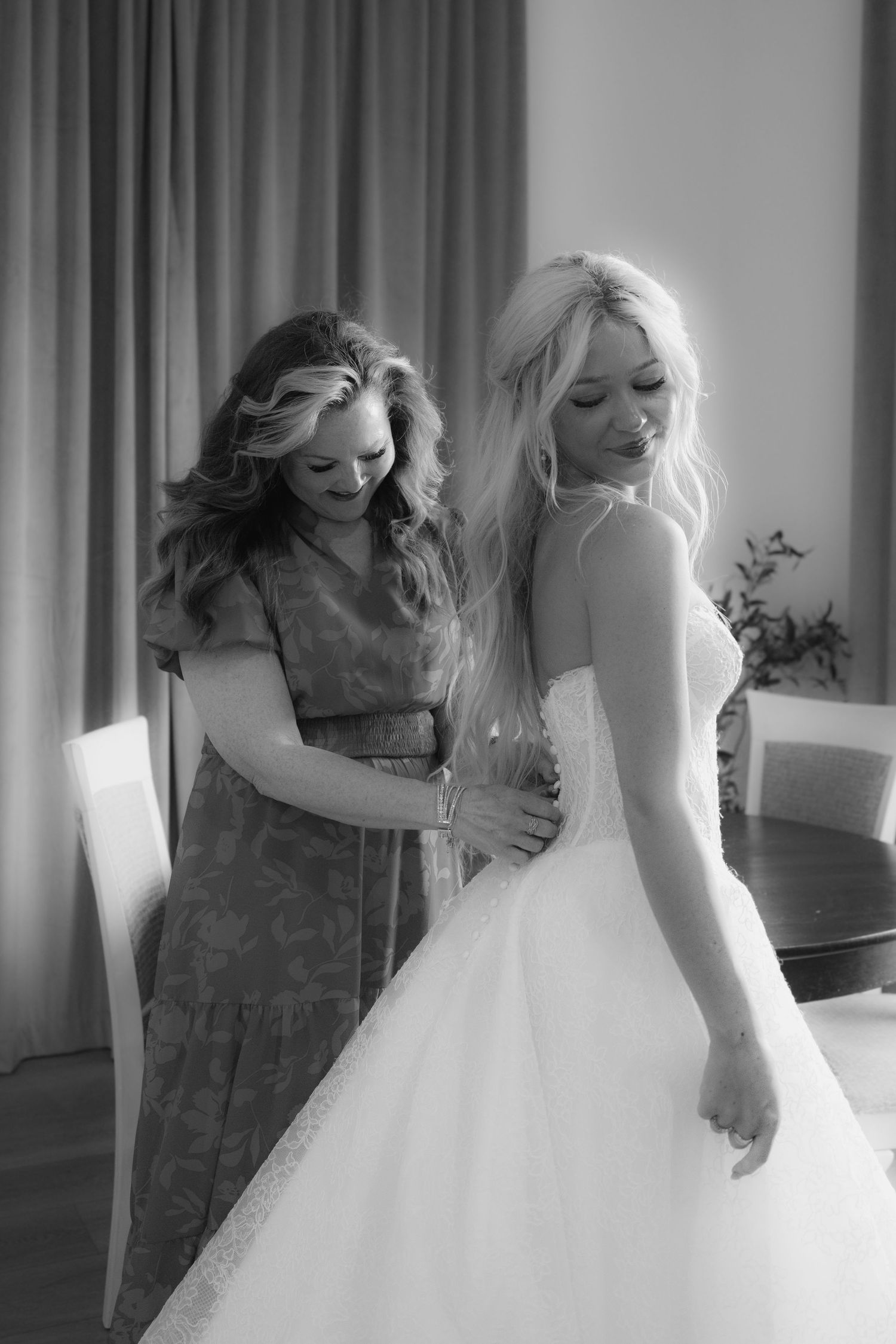 A wedding dress being fitted and adjusted in a series of black and white photographs showing close-up details.