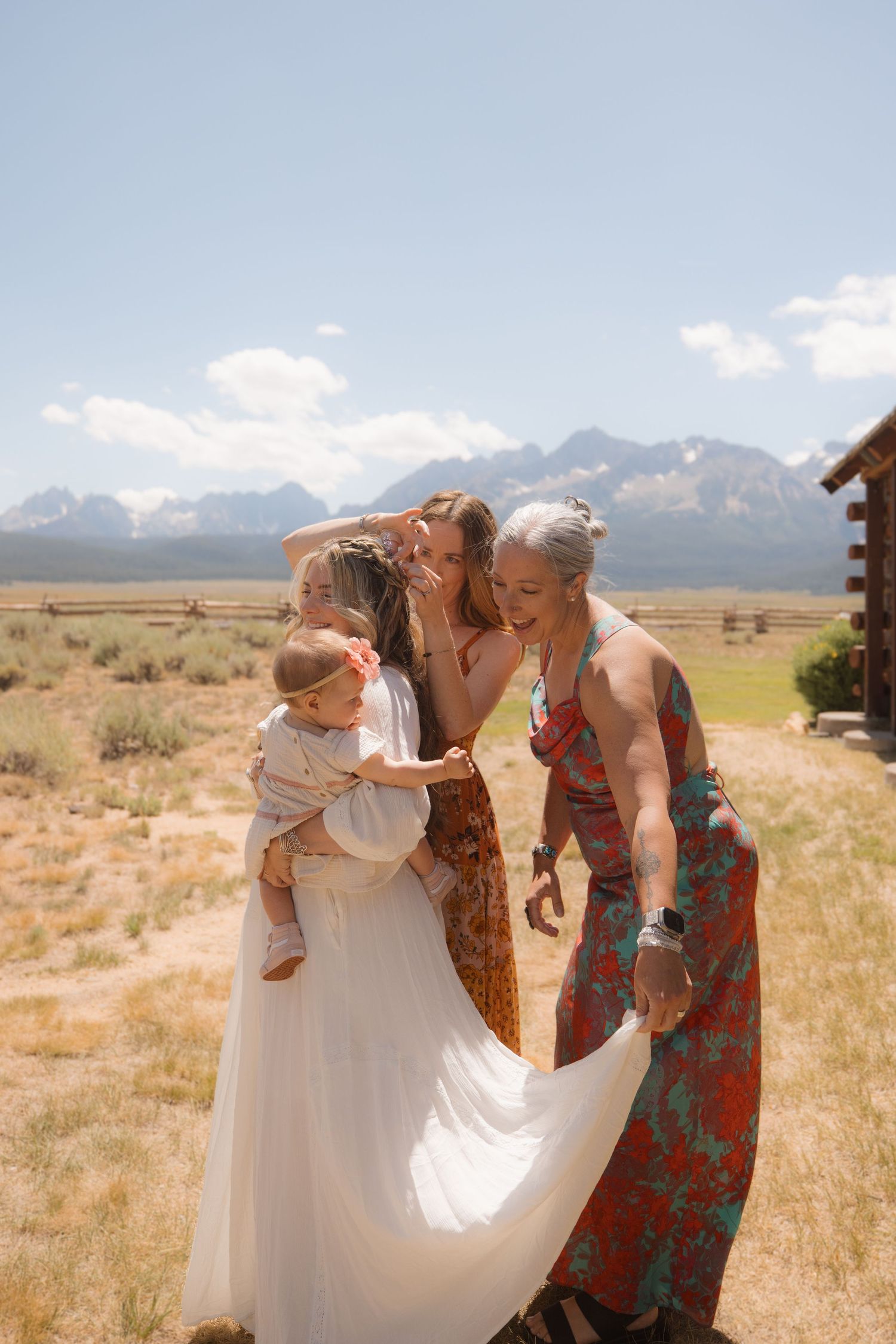 A joyful moment shared between loved ones in a white dress against a backdrop of mountains and desert landscape.