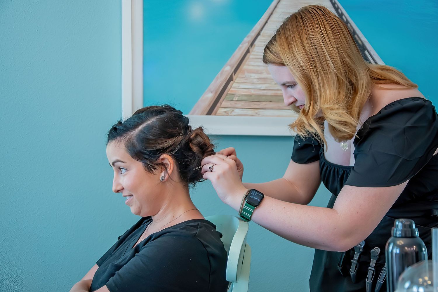 Professional hair styling session in progress with stylist working on client's hair.