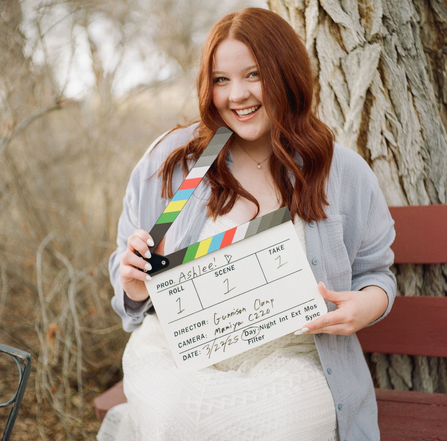 Film portrait photo of Ashlee Petranovich with a movie director's clapboard.