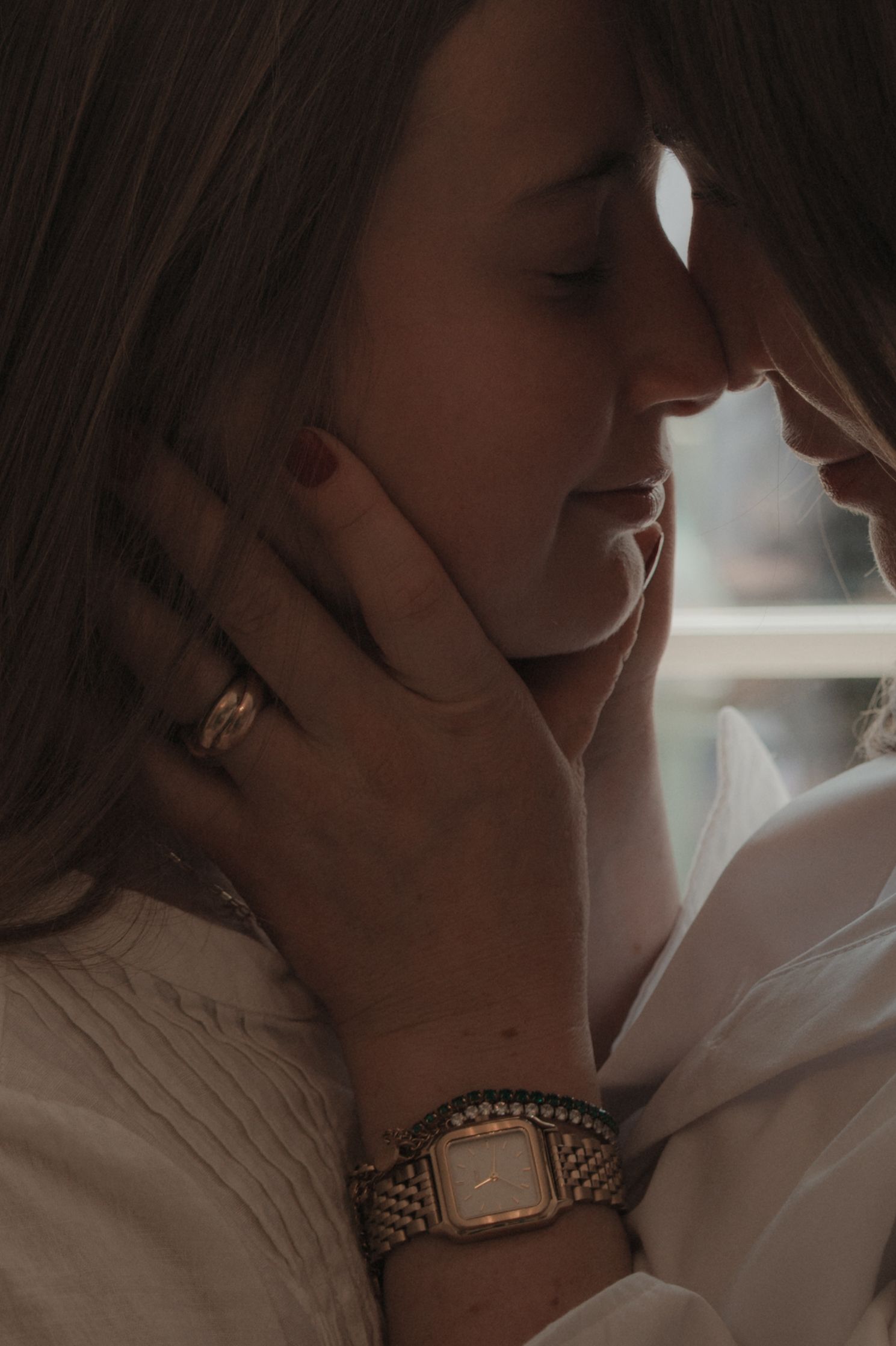close up portrait of mother and daughter ,foreheads together sharing a tender moment of connection