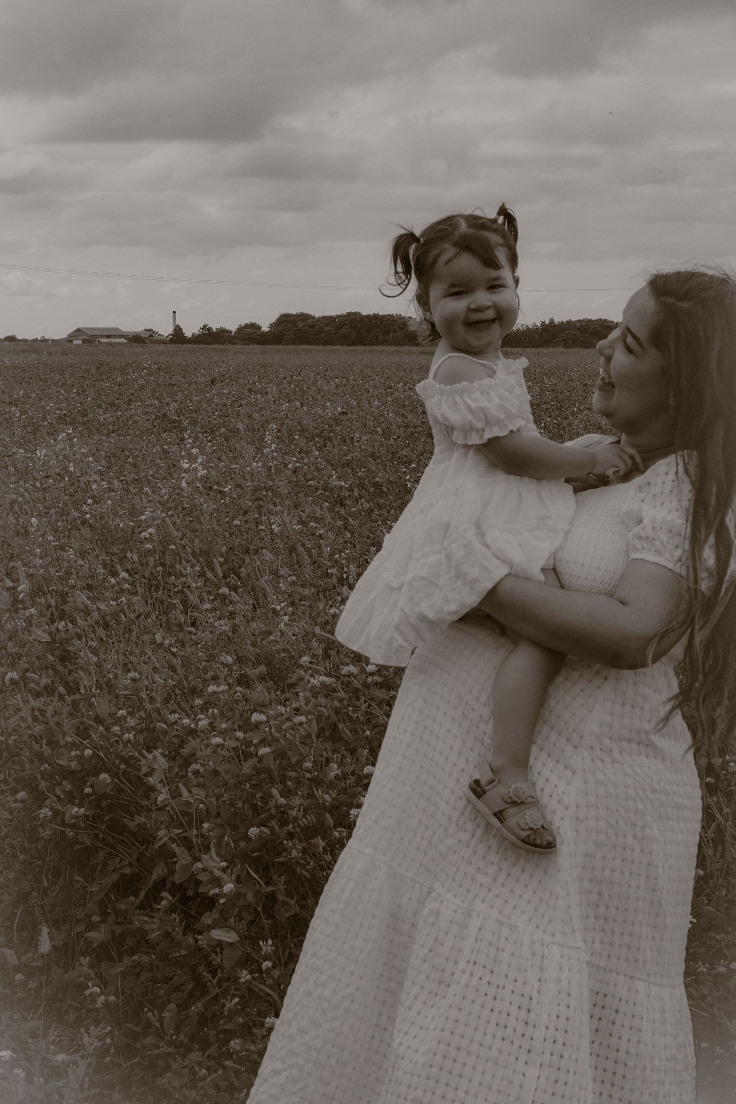 cinematic, monochrome portrait of woman and her little girl  in a wild flower field in Suffolk, captured by Untamed Muses